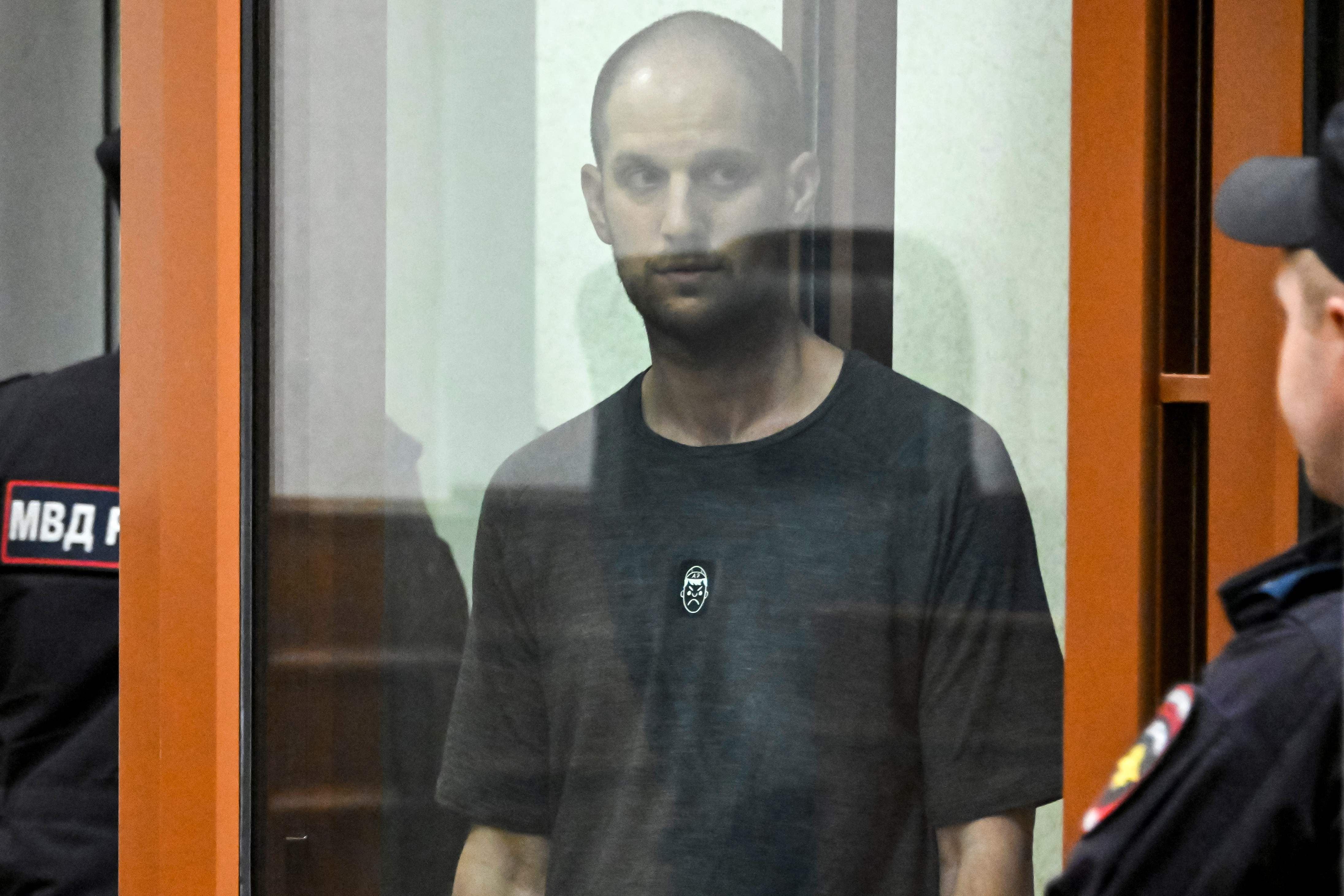 El periodista estadounidense Evan Gershkovich, acusado de espionaje, se encuentra en una jaula de cristal para acusados durante la lectura del veredicto en el Tribunal Regional de Sverdlovsk en Ekaterimburgo el 19 de julio de 2024. (Foto de Alexander NEMENOV / AFP)