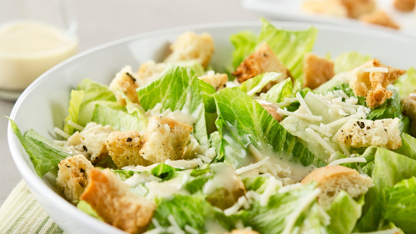 La ensalada César se compone de lechuga romana crujiente, aderezo especial de mayonesa y parmesano, y variantes que incluyen pollo o salmón.