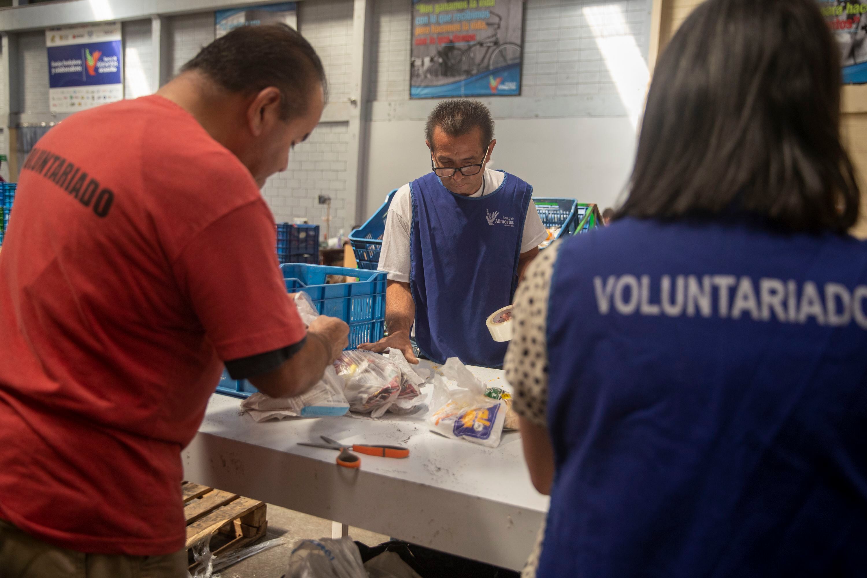 Un grupo de voluntarios reparan defectos mínimos que presentan paquetes de alimentos. En la fotografía se ve a Jesús Alberto Rodríguez. 