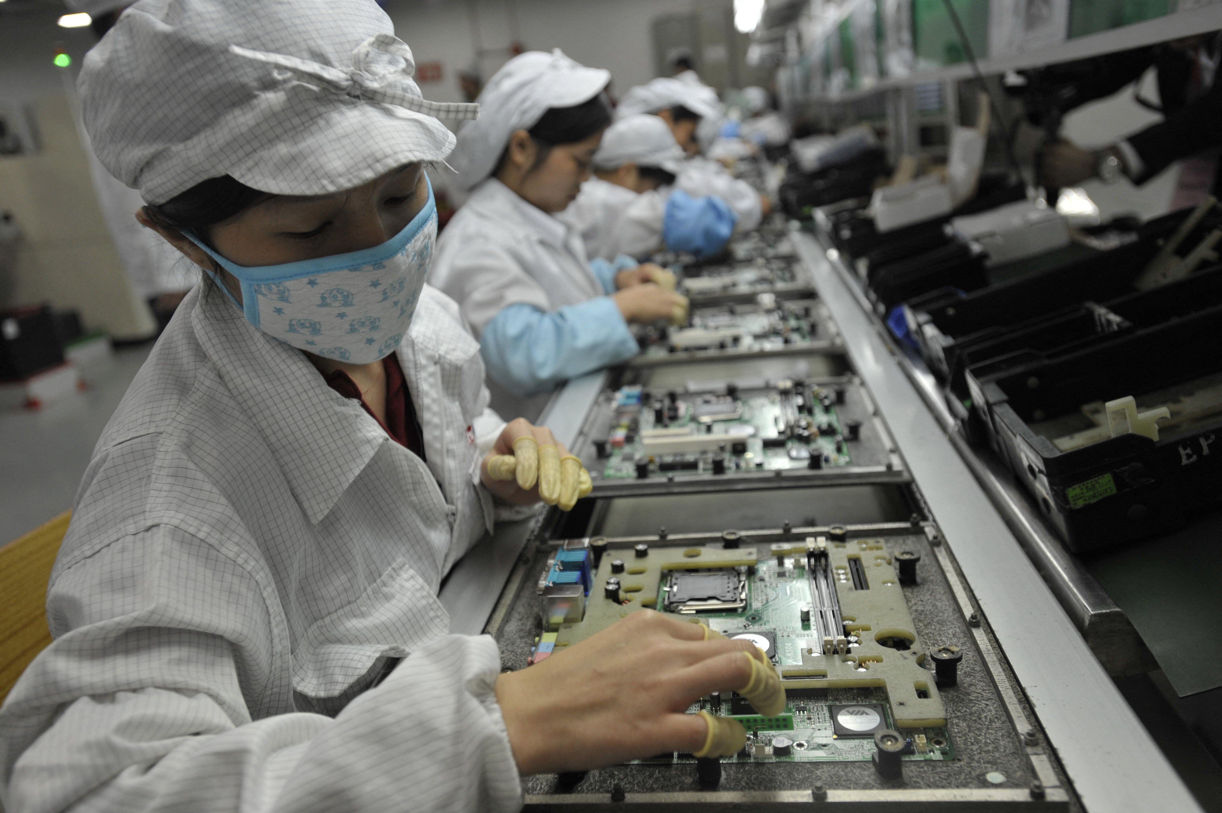 Esta foto de archivo tomada el 27 de mayo de 2010 muestra a los trabajadores chinos en la fábrica de Foxconn en Shenzhen, en la provincia de Guangdong, en el sur de China. - El 23 de noviembre de 2022 estallaron violentas protestas alrededor de la gran fábrica de iPhone de Foxconn en el centro de China, cuando los trabajadores se enfrentaron con el personal de seguridad por las restricciones de Covid en la planta