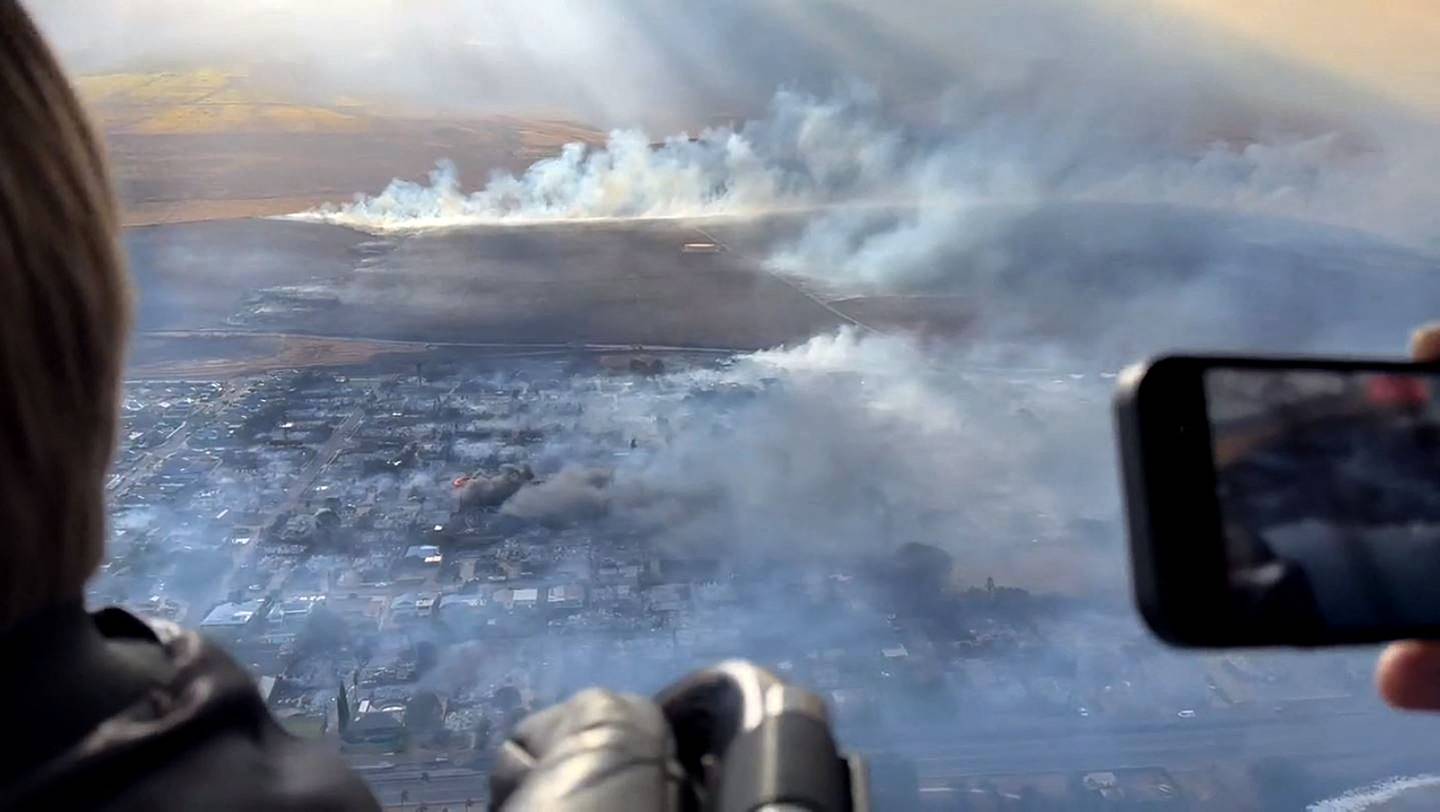 Esta captura de video del folleto, cortesía de Richard Olsten, tomada el 9 de agosto de 2023, muestra el humo que sale de los edificios destruidos en Lahaina mientras los incendios forestales arden en Maui, Hawái.