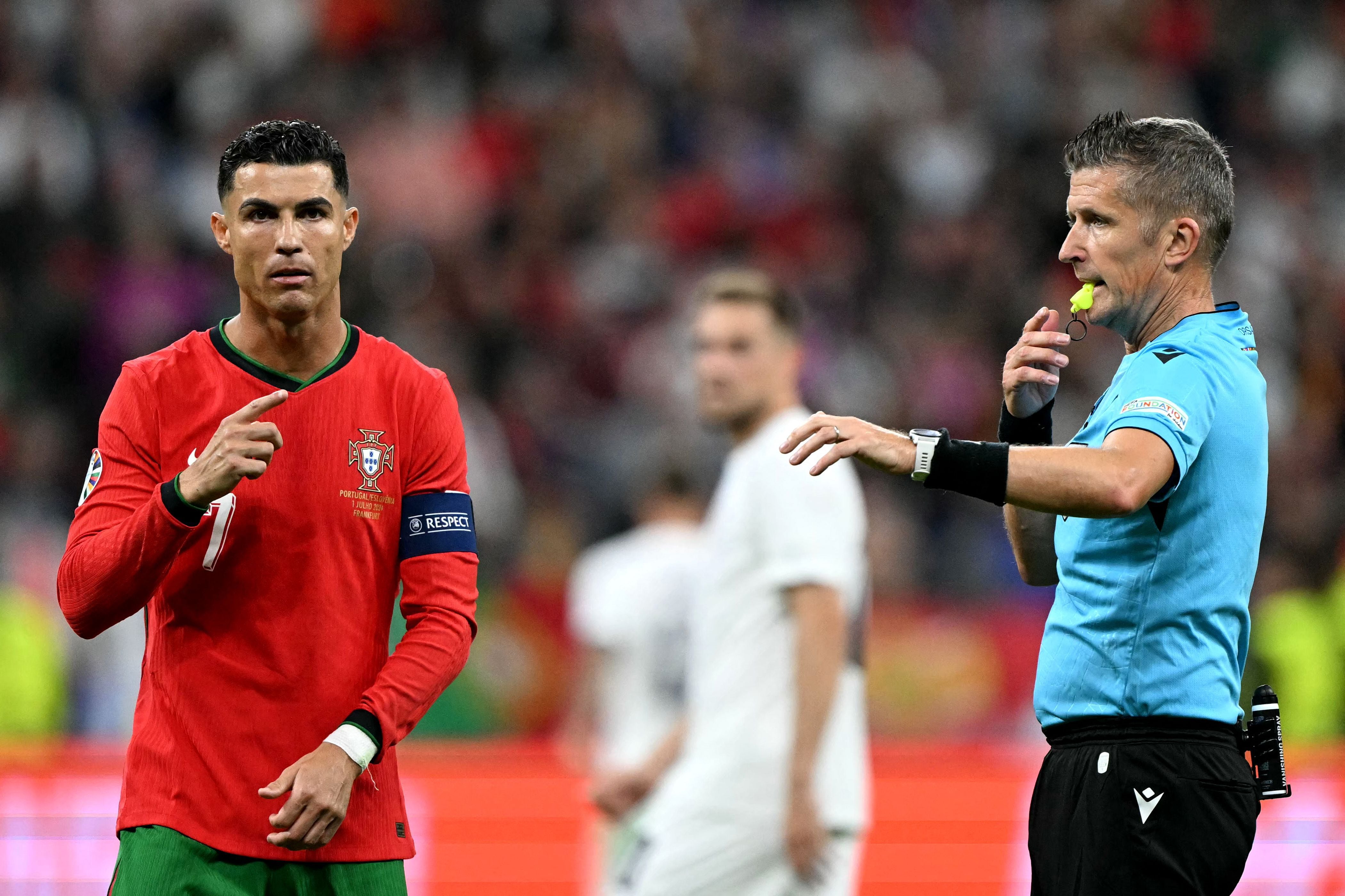 El capitán de Portugal, Cristiano Ronaldo (#07, izquierda), reacciona flanqueado por el árbitro italiano Daniele Orsato durante el partido de octavos de final de la UEFA Euro 2024 entre Portugal y Eslovenia en el Frankfurt Arena de Frankfurt am Main el 1 de julio de 2024. (Foto: PATRICIA DE MELO MOREIRA/AFP)