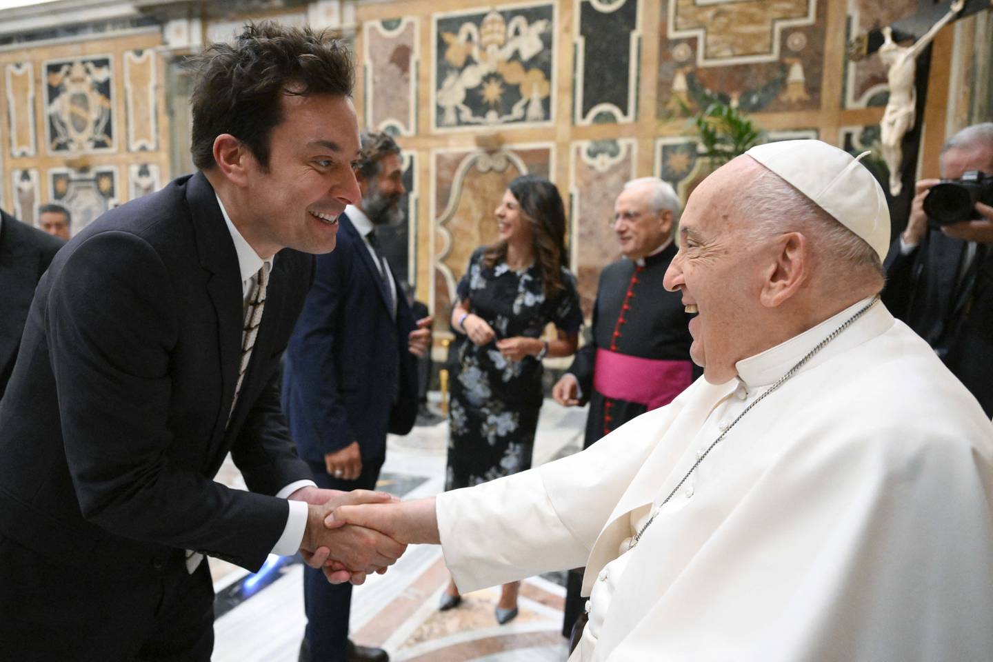 This photo taken and handout on June 14, 2024 by The Vatican Media shows Pope Francis shaking hand with US actor Jimmy Fallon as part of an audience with comedians  in The Vatican. (Photo by Handout / VATICAN MEDIA / AFP) / RESTRICTED TO EDITORIAL USE - MANDATORY CREDIT "AFP PHOTO / VATICAN MEDIA" - NO MARKETING - NO ADVERTISING CAMPAIGNS - DISTRIBUTED AS A SERVICE TO CLIENTS