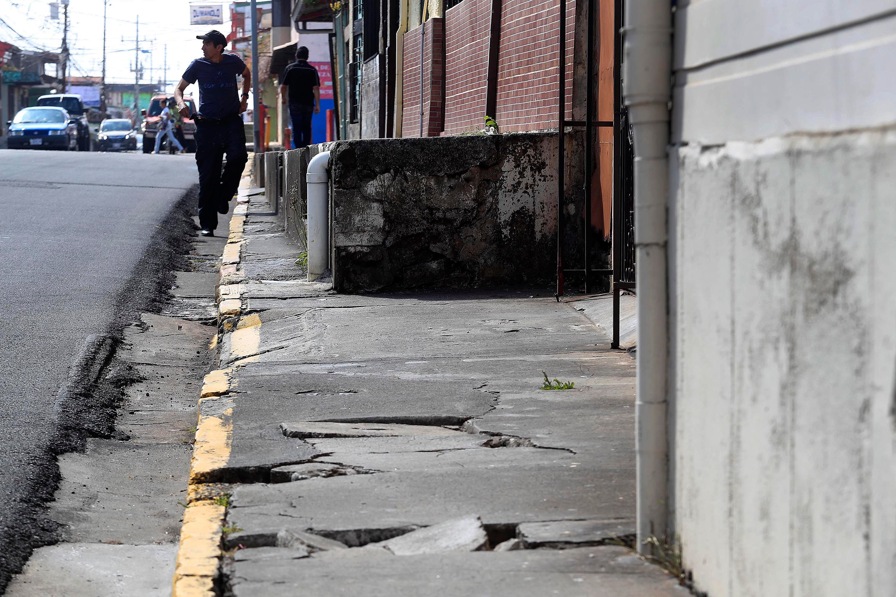 Deficiencias en la infraestructura de aceras obligan a los peatones a exponerse al riesgo y tirarse a la calle. El transeúnte de la fotografía caminaba a escasos metros del Mercado Central de Heredia. 