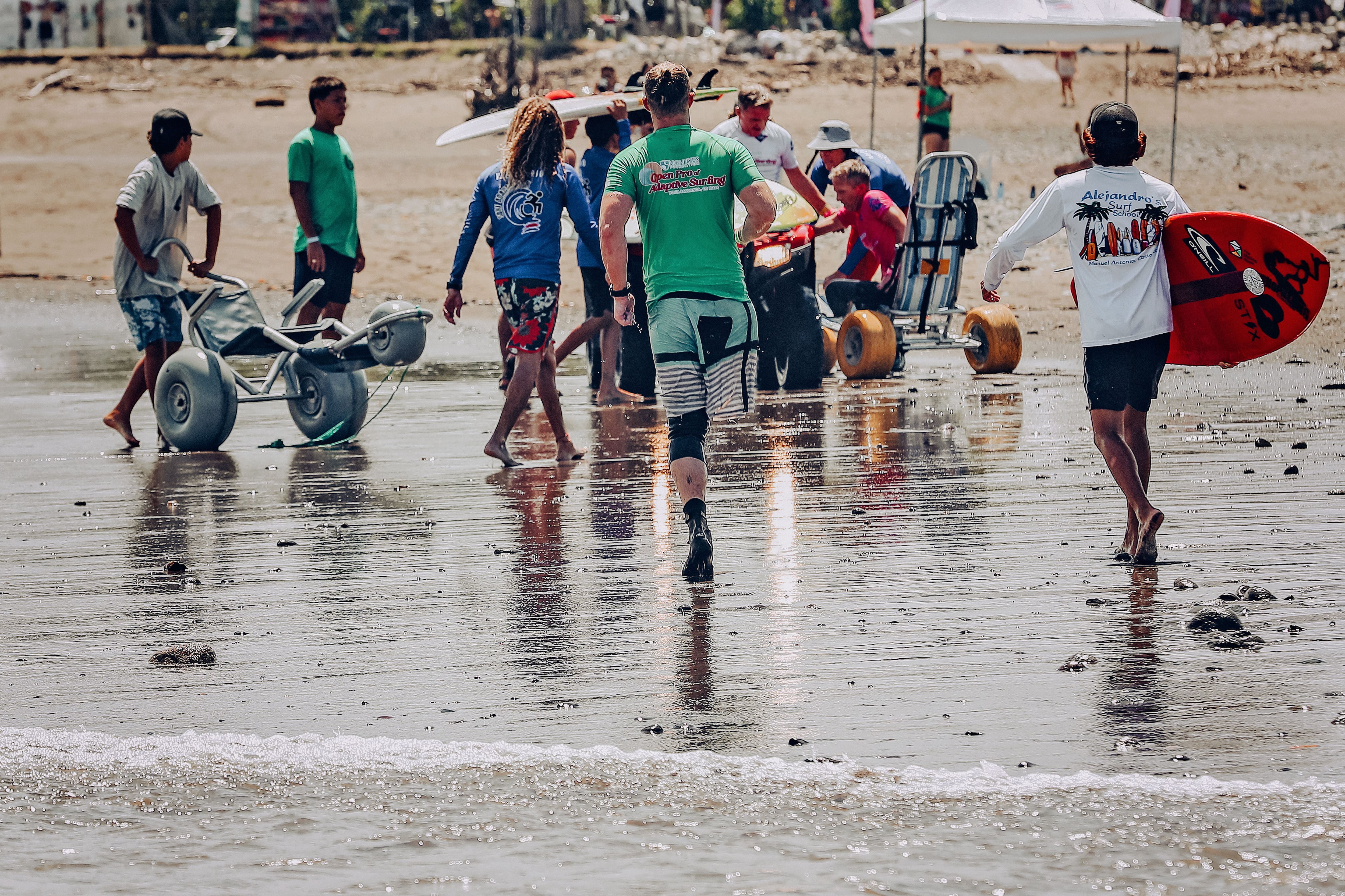 Antes de ingresar al mar para competir, los surfistas se aproximan a la costa con la ayuda de los voluntarios. El puesto de los tres jueces que los calificará está a 200 metros de la costa, por lo que los binoculares son clave para otorgar las puntuaciones correctas.