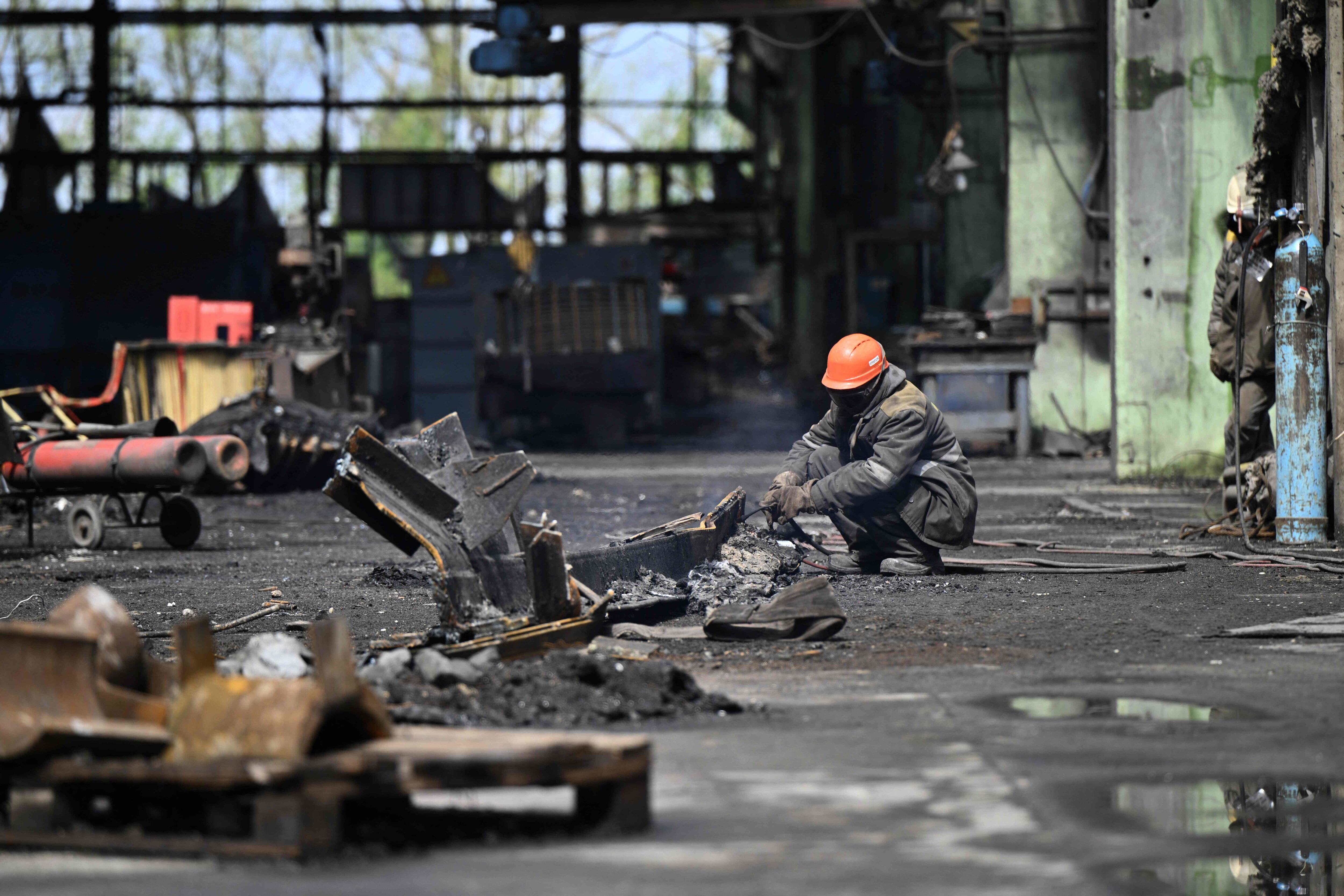 Las centrales energéticas de Rusia y Ucrania son blancos de ataques. Un trabajador recoge los escombros de la central energética rusa que fue atacada por Ucrania en el mes de abril. FOTO: AFP