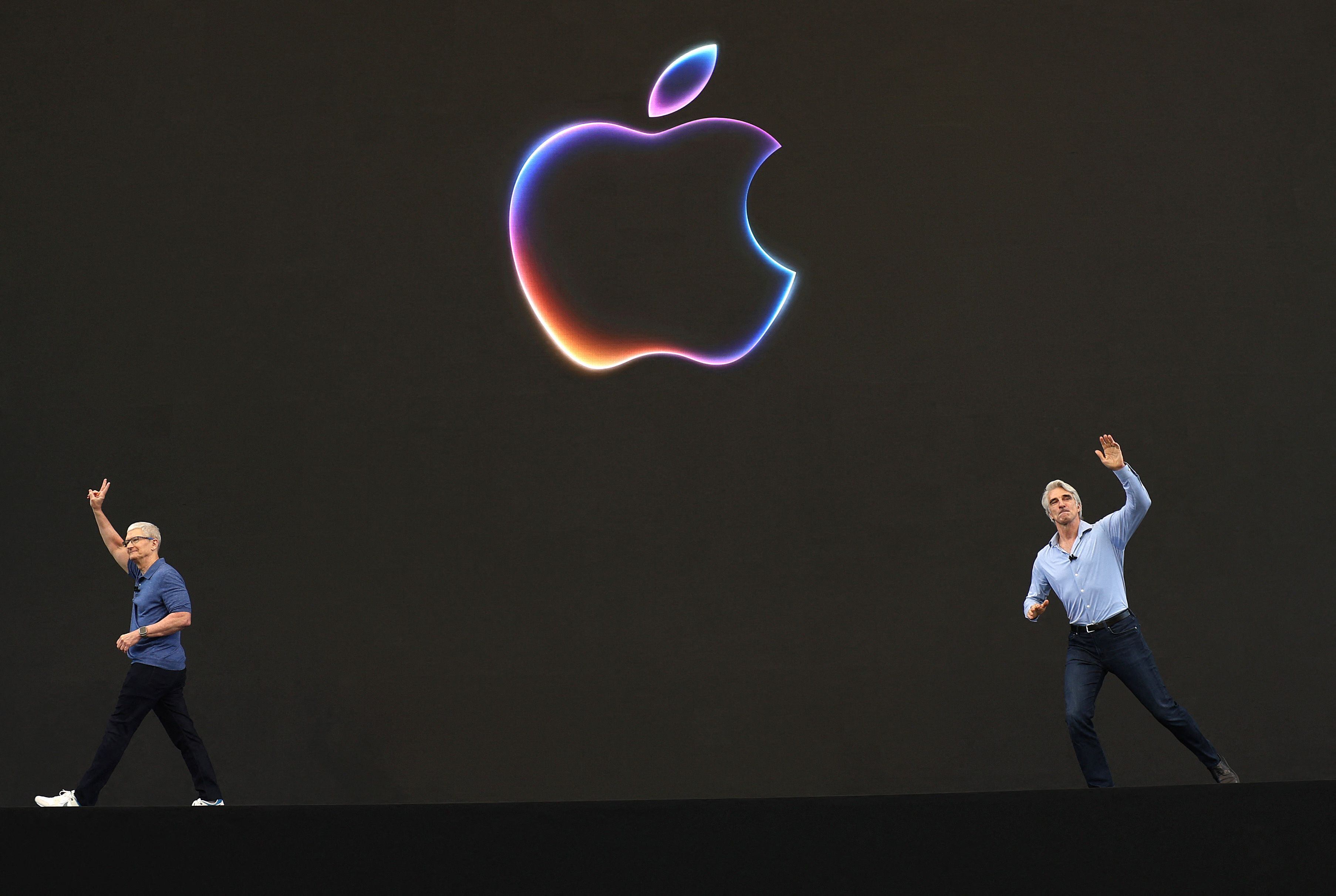 El CEO de Apple, Tim Cook (Izq) y el vicepresidente senior de ingeniería de software de Apple, Craig Federighi (der), saludan a los asistentes al comienzo de la Conferencia Mundial de Desarrolladores de Apple (WWDC) el 10 de junio de 2024 en Cupertino, California. Apple anunciará planes para incorporar inteligencia artificial (IA) en el software y el hardware de Apple. (Foto de Justin Sullivan / Getty Images North America / Getty Images a través de AFP)