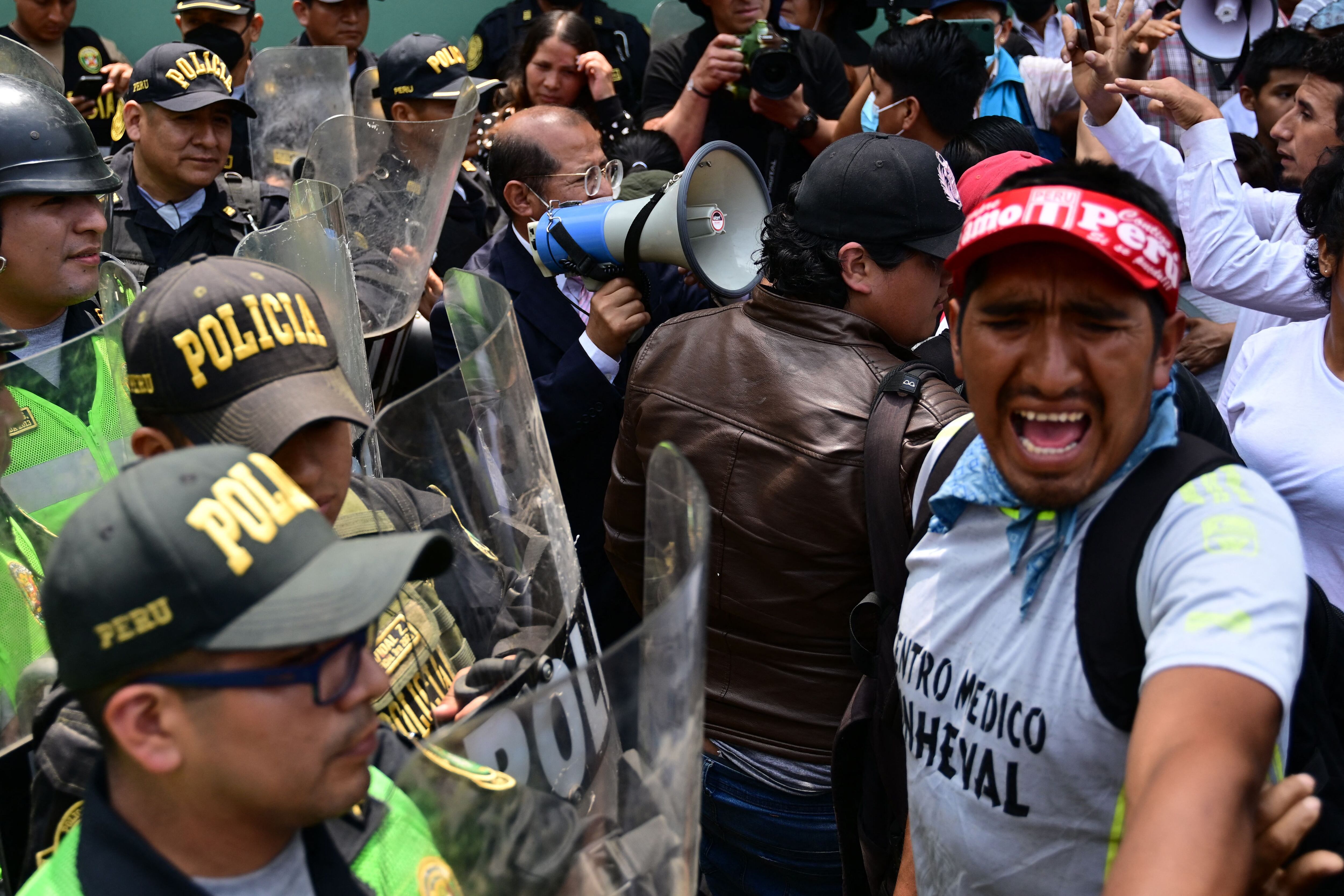 Partidarios del expresidente peruano Pedro Castillo chocan con la policía durante una manifestación exigiendo su liberación frente a la dependencia policial DIROES en Ate, al este de Lima, donde está detenido Castillo, el 14 de diciembre de 2022