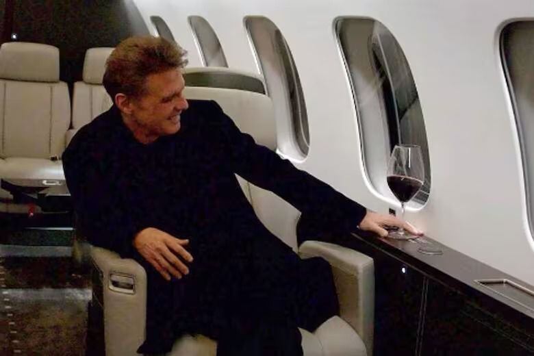 Luis Miguel aparece sonriente y disfrutando de una copa de vino en el lujoso avión. 