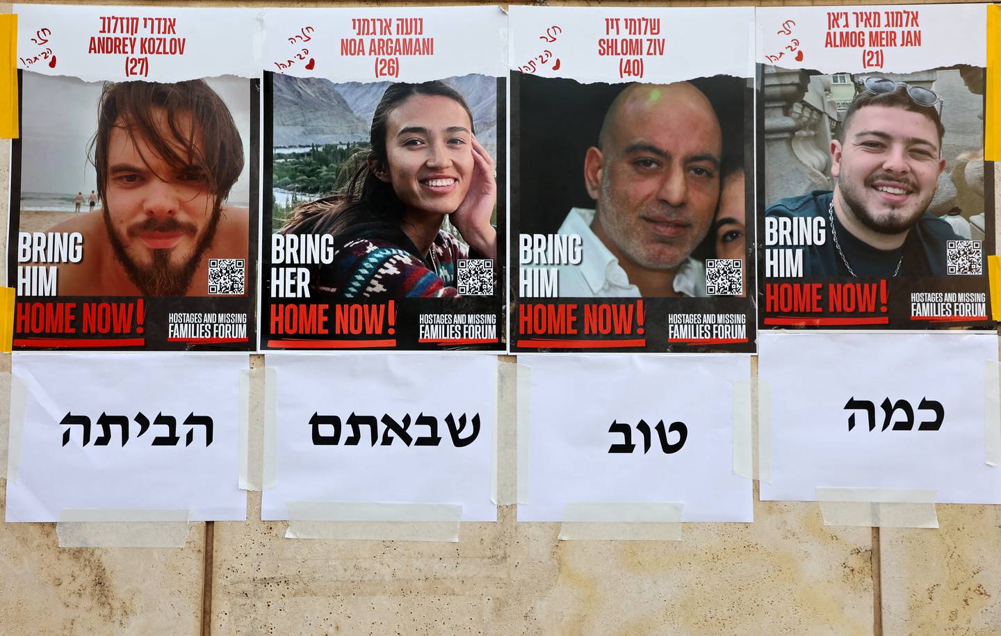 Carteles que dicen 'Home Now' (en casa ahora) que representan los retratos de los cuatro rehenes israelíes rescatados desde la izquierda: Andrey Kozlov, 27, Noa Argamani, 26, Shlomi Ziv, 41, y Almog Meir Jan, 22, están pegados en una pared en Tel Aviv.