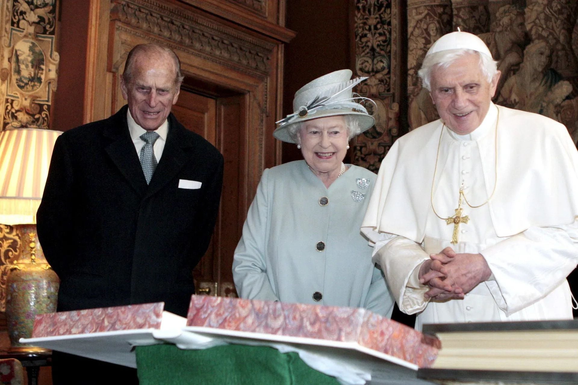 El duque de Edimburgo observa mientras la reina Isabel II de Inglaterra y el papa Benedicto XVI intercambian regalos durante su encuentro en el Palacio de Holyrood House en Edimburgo, el 16 de septiembre de 2010. Foto: Archivo
