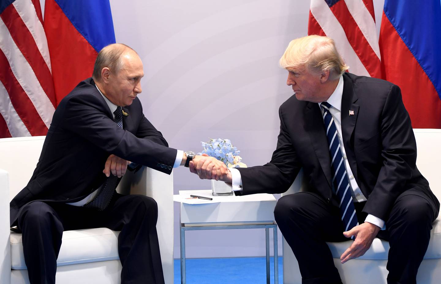 Donald Trump y Vladimir Putin estrechan sus manos en una reunión que tuvieron en el 2017 previo al G-20 en Hamburgo, Alemania. Foto: AFP