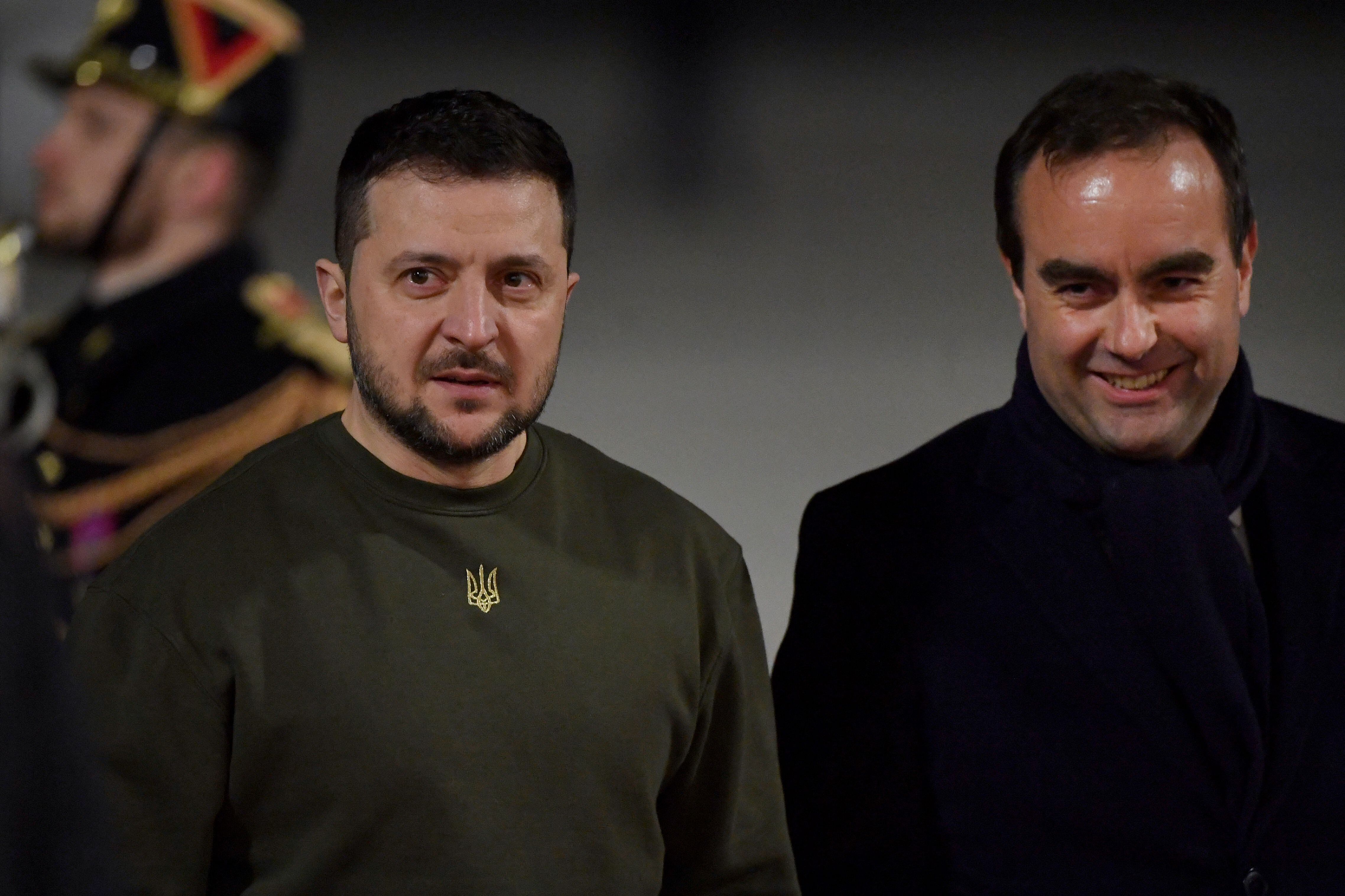 El presidente de Ucrania, Volodymyr Zelensky (izquierda), es recibido por el ministro del ejército francés, Sebastien Lecornu (derecha), a su llegada al aeropuerto de París Orly, en las afueras de París, el 8 de febrero de 2023, luego de su visita al Reino Unido.