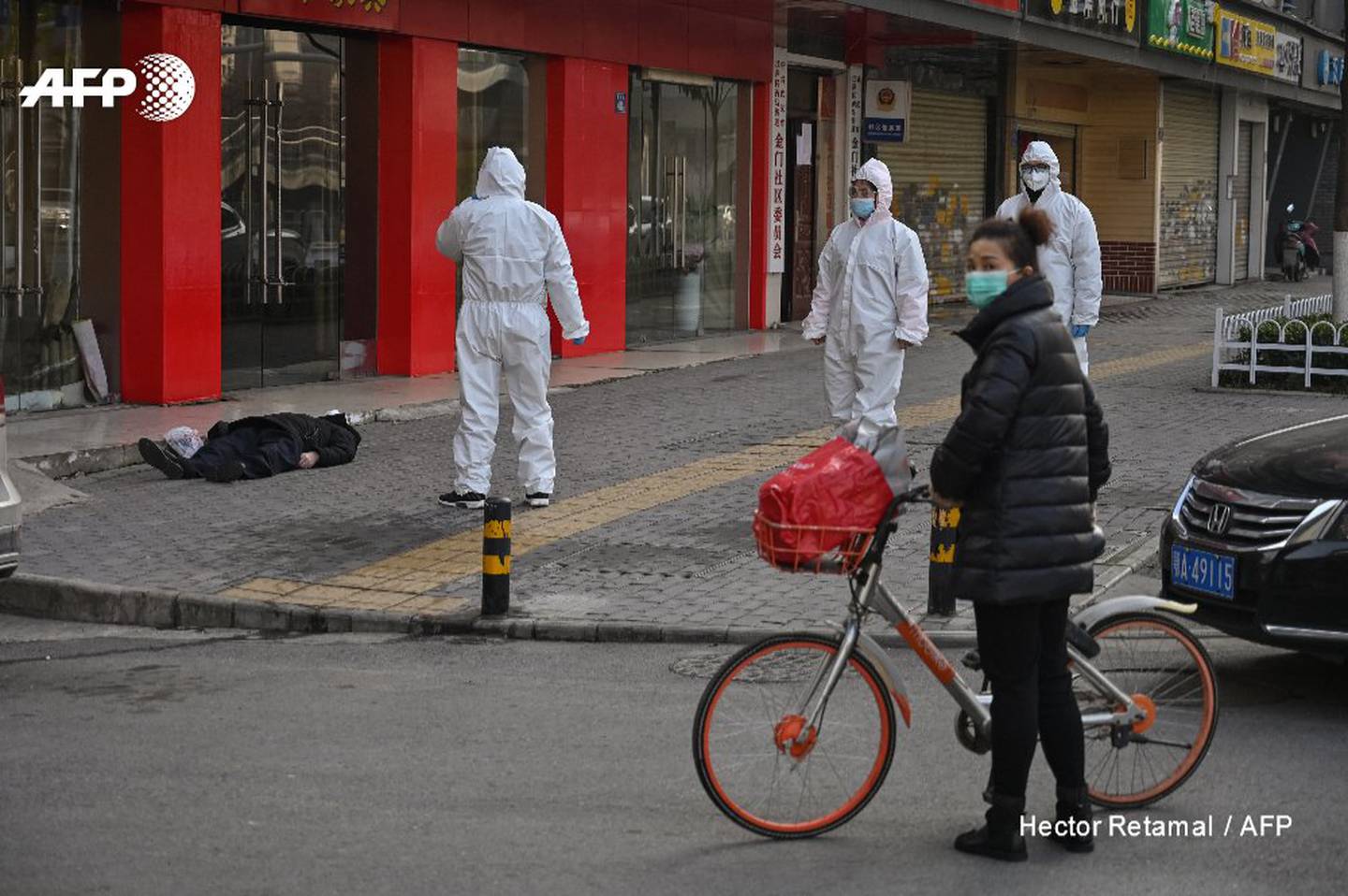 El cadaver de un hombre yace en medio de una calle en el centro de Wuhan, China, a finales de enero de 2020. Foto: Héctor Retamal / AFP