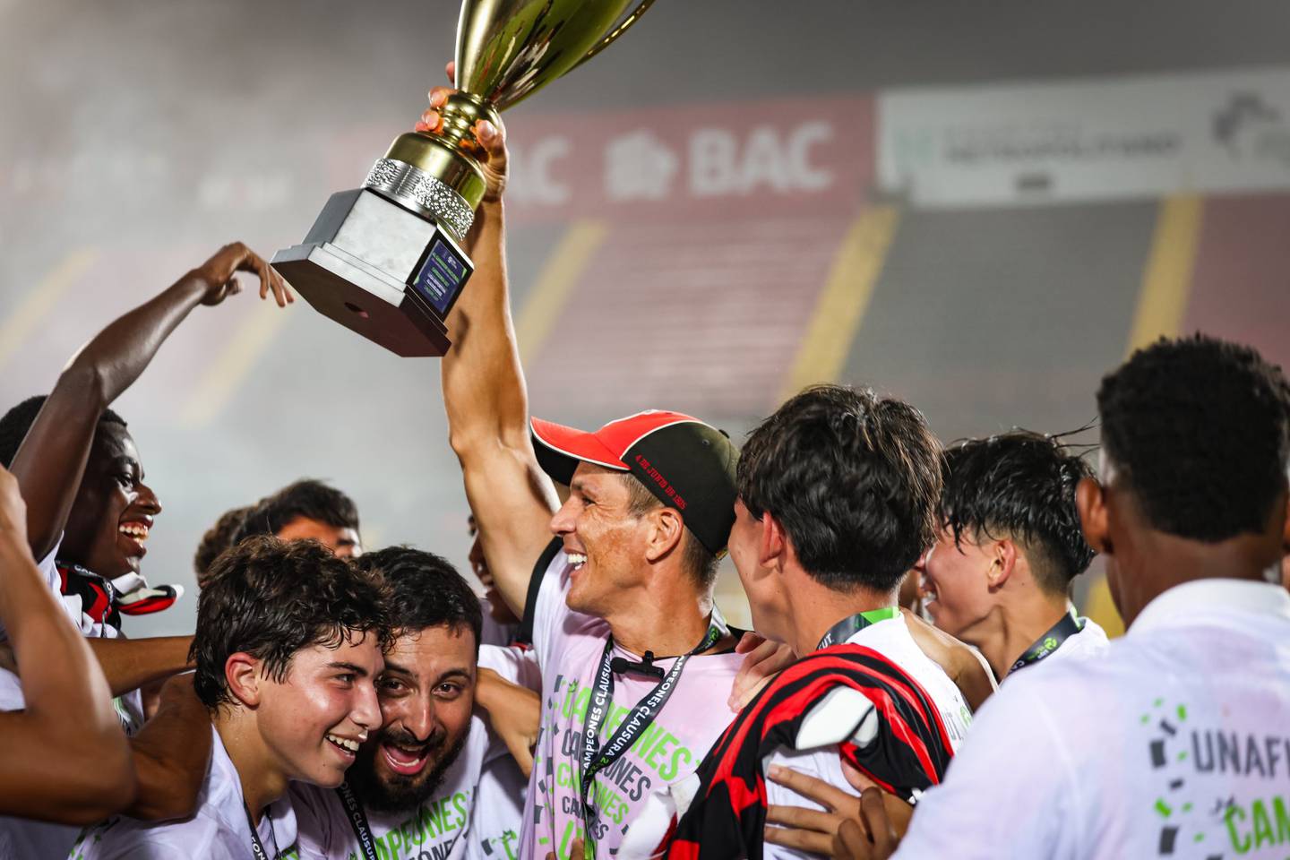 Wardy Alfaro levanta la copa ganada por sus pupilos de la U-17 de Liga Deportiva Alajuelense.