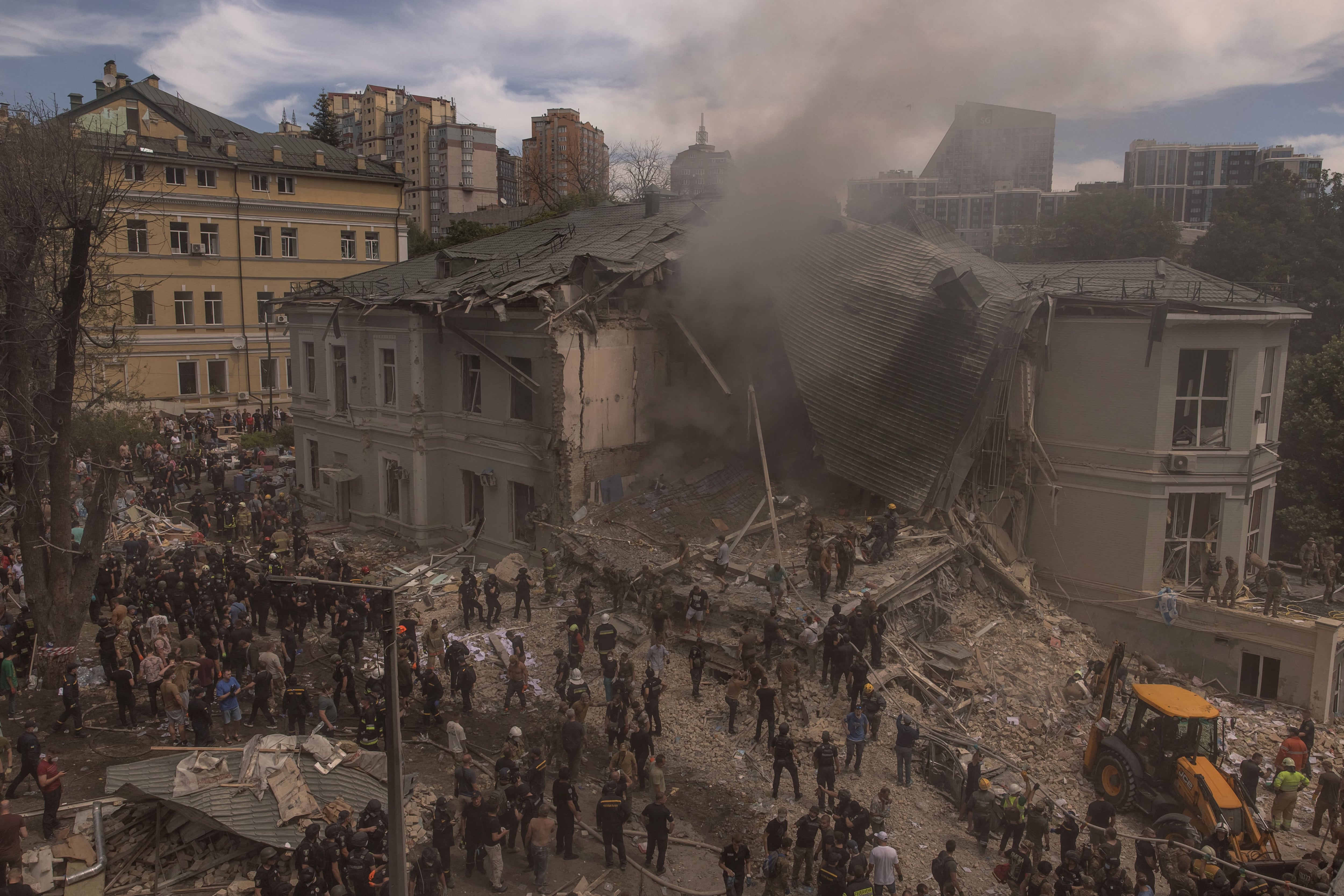 El personal de emergencia y rescate junto con médicos y otras personas limpian los escombros del edificio destruido del Hospital Infantil Ohmatdyt luego de un ataque con misiles rusos en la capital ucraniana de Kiev.