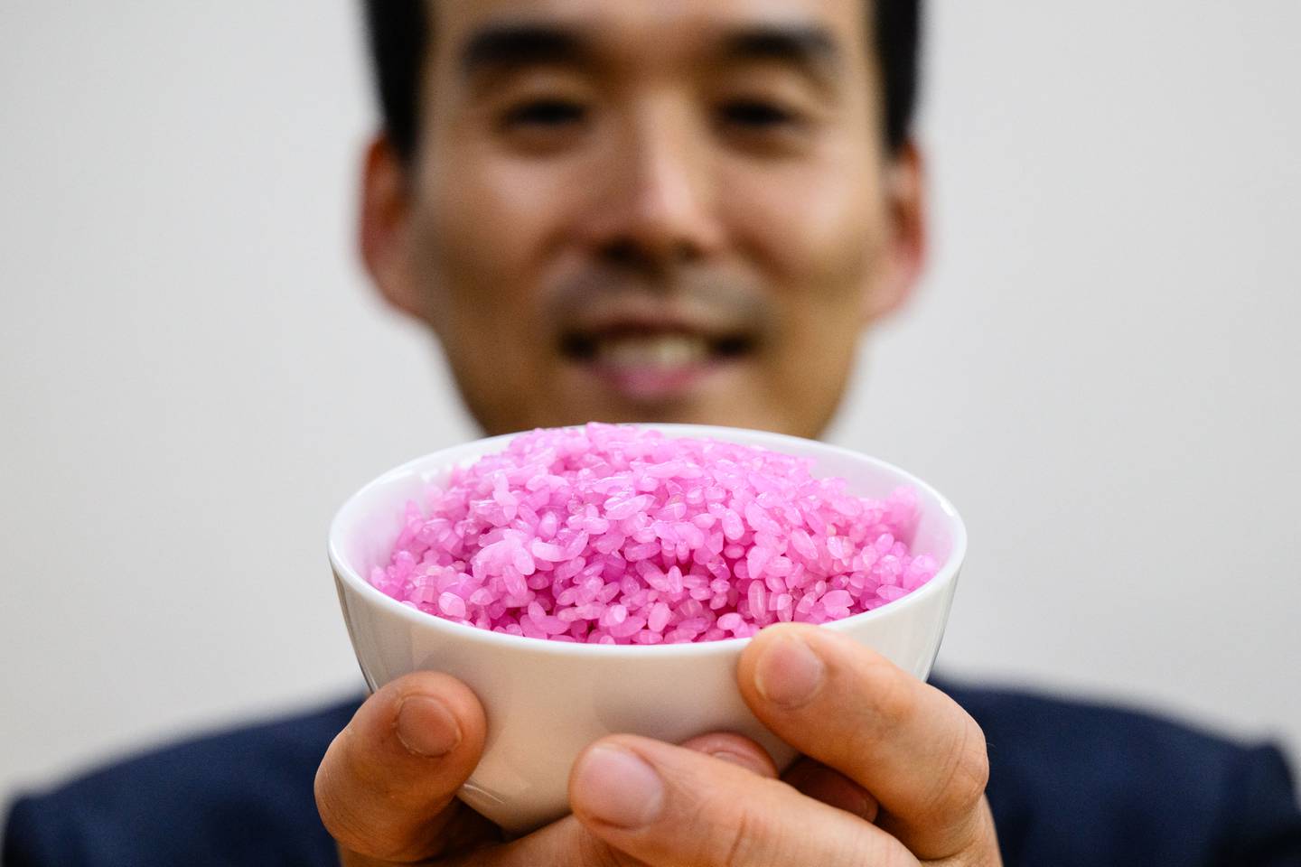 El profesor Hong Jin-kee posando con un cuenco que contiene 'arroz con carne' rosa en la Universidad Yonsei en Seúl.