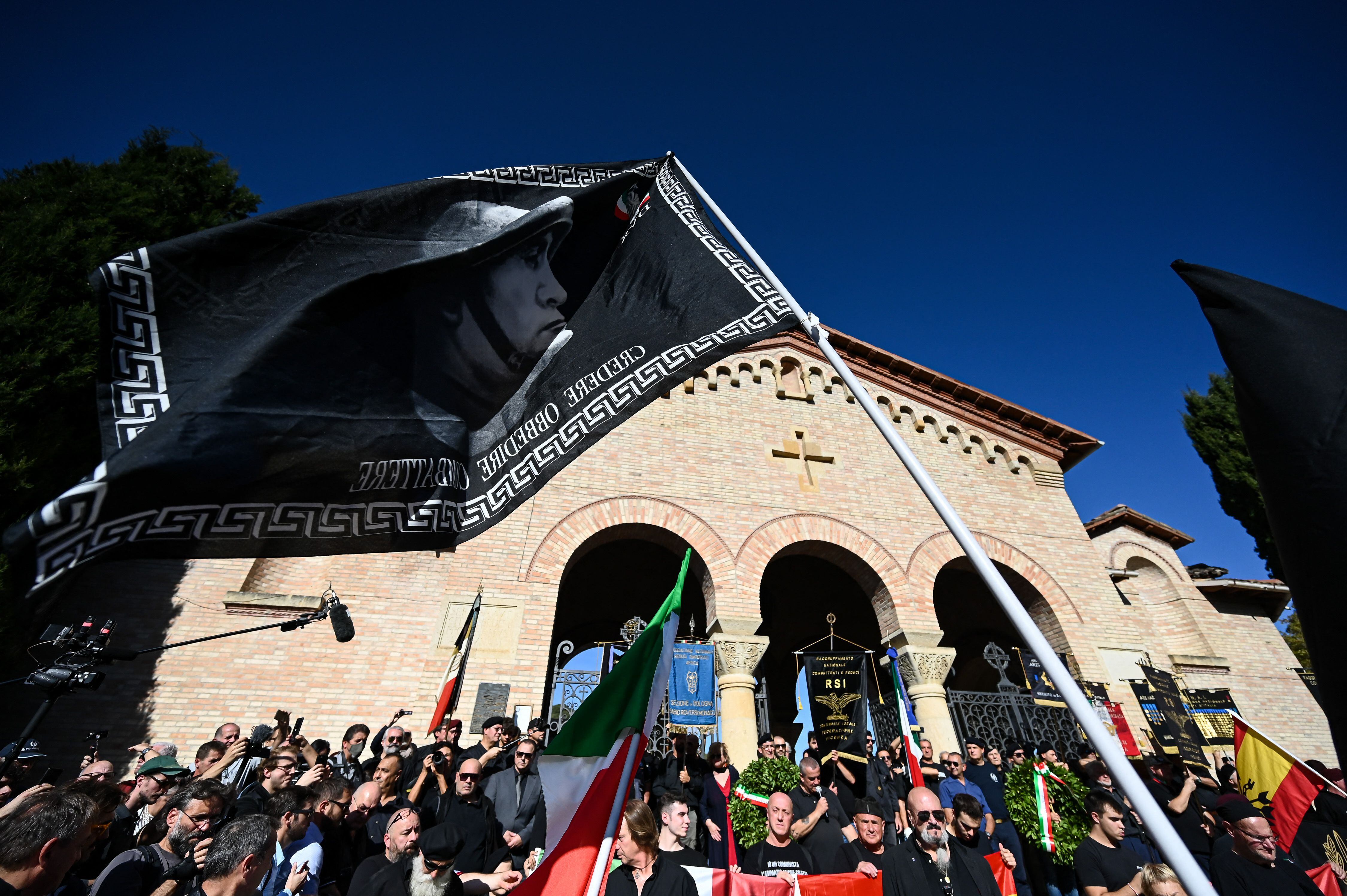 Una gigantesca bandera de color negro, con el rostro de Mussolini, ondeó durante la concentración.