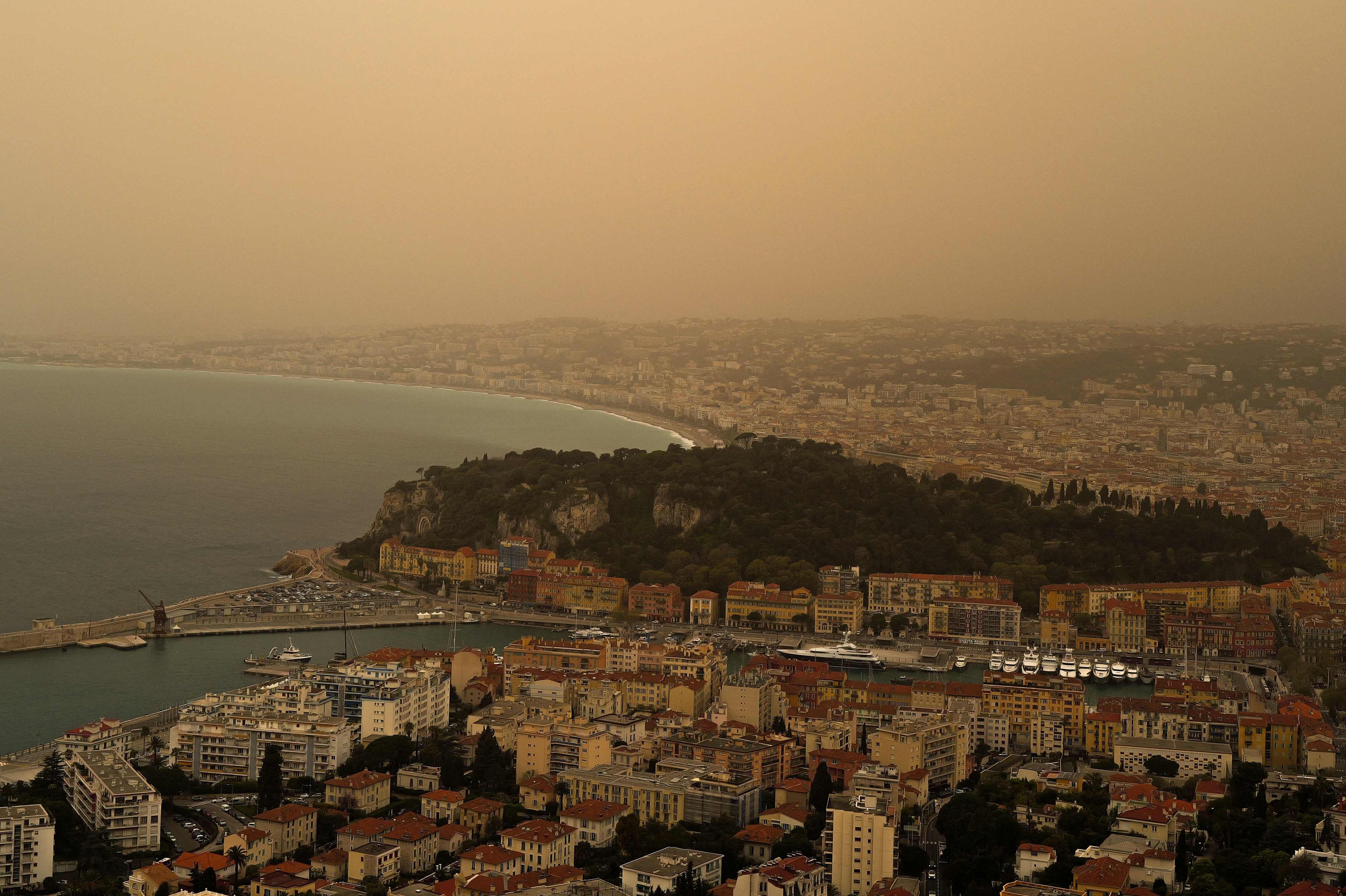 Esta fotografía tomada este sábado muestra un espeso polvo de arena arrastrado desde el Sahara dando al cielo una apariencia amarillenta sobre la ciudad de Niza, en la Riviera francesa, en el sur de Francia. Este color se debe a la arena arrastrada desde el desierto del Sahara y el norte de África. (Foto de Valery HACHE / AFP)