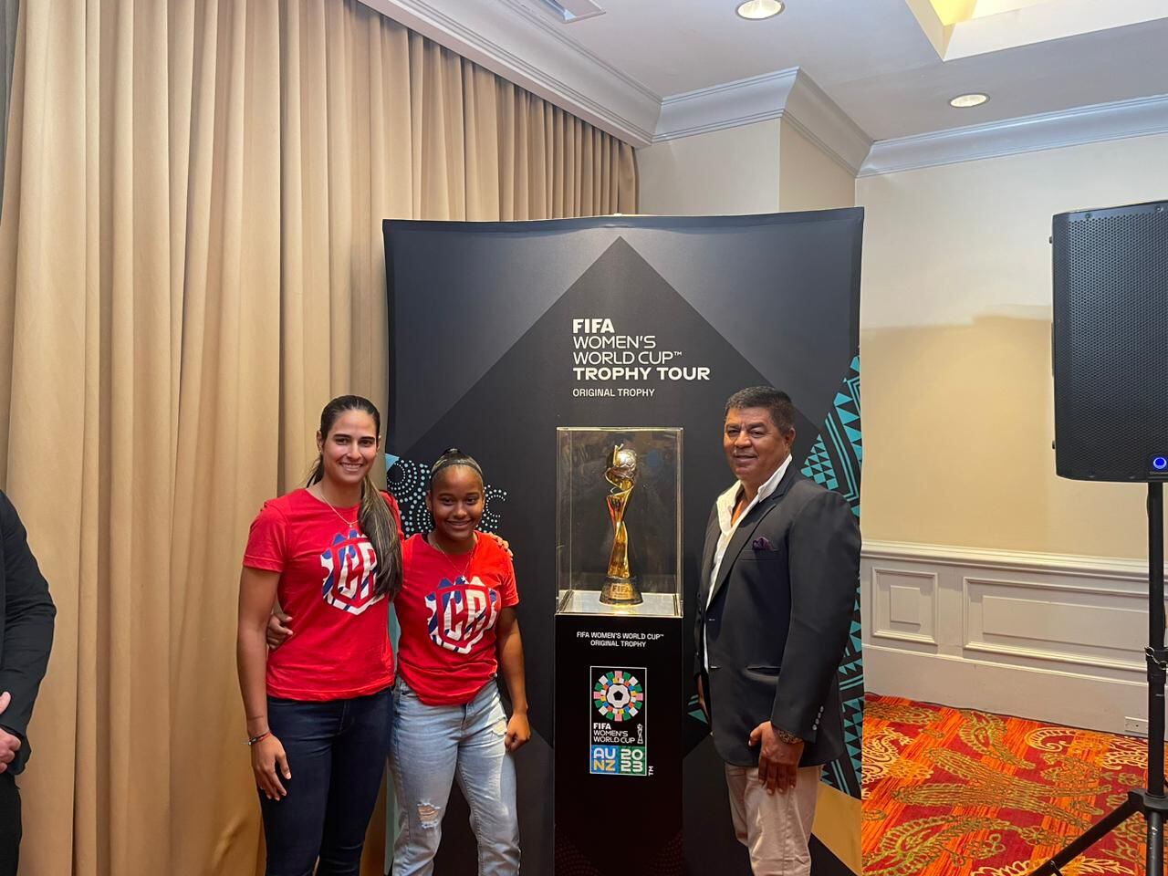 Patricia Aguilar, Sheika Scott y Víctor Hugo Alfaro junto al trofeo de la Copa Mundial Femenina. 
