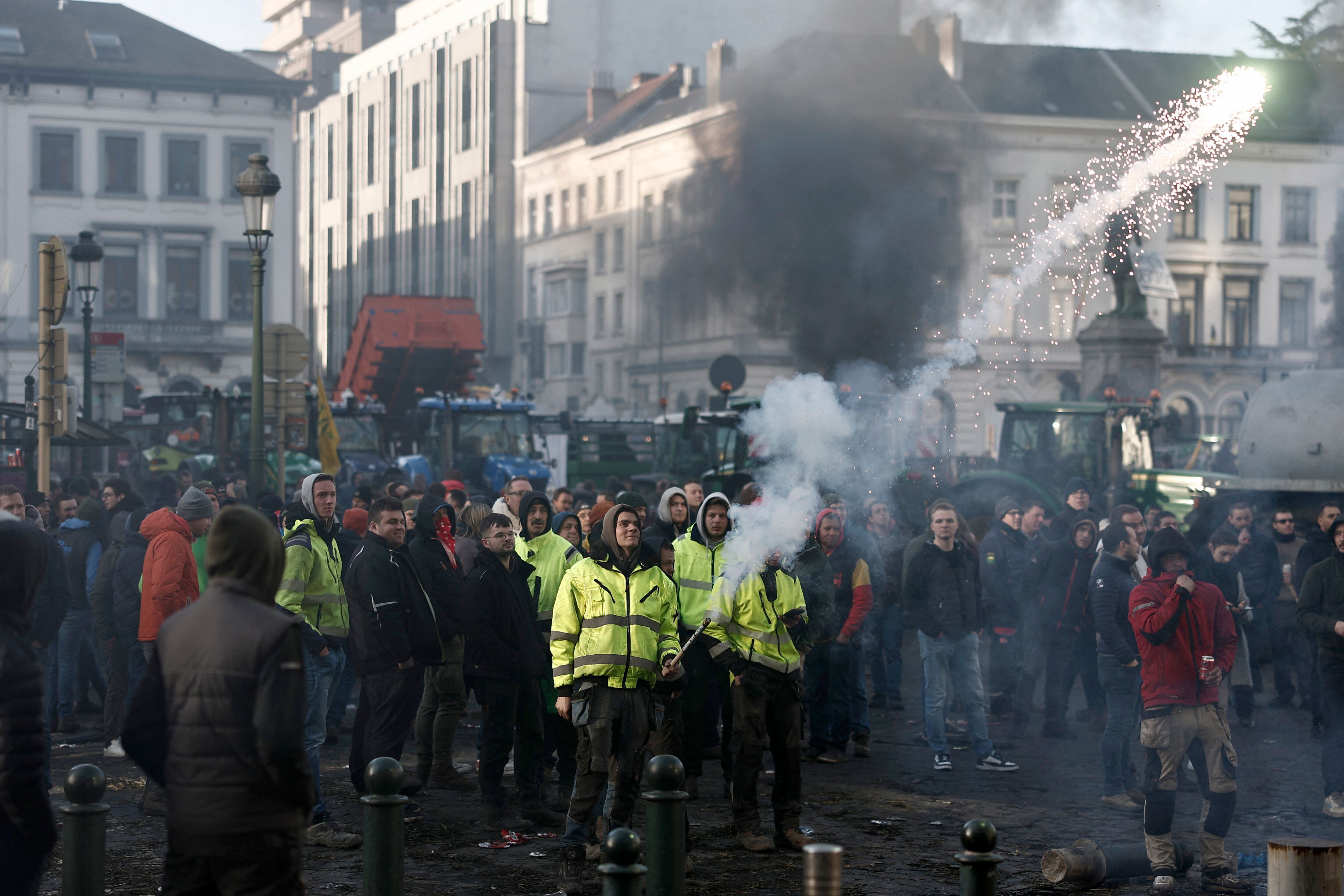 Un manifestante se enfrenta a la policía durante una protesta de agricultores que pide mayores ingresos y protección contra la competencia extranjera, en la Place du Luxemburgo, cerca del edificio del Parlamento Europeo en Bruselas.