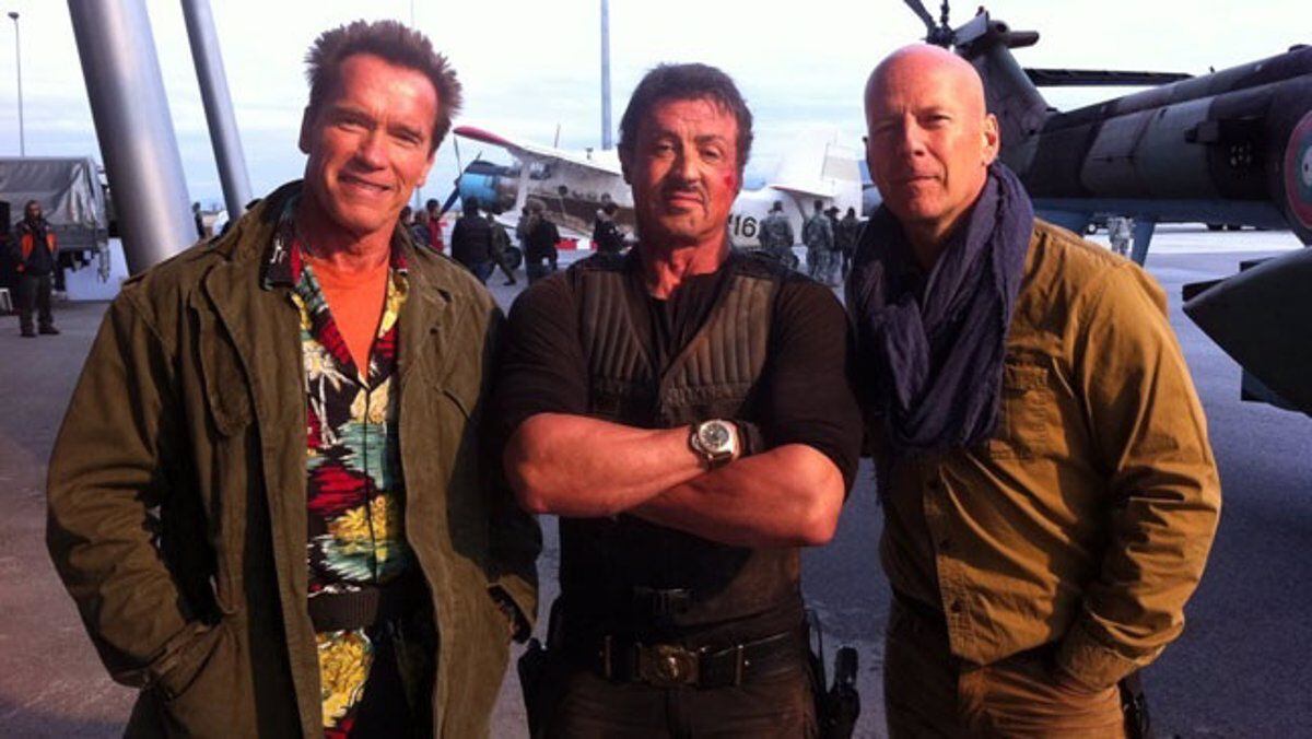 Arnold Schwarzenegger, Sylvester Stallone y Bruce Willis en un afiche promocional de la segunda entrega de 'Los indestructibles'. Los tres son recordados como emblemas del cine de acción.