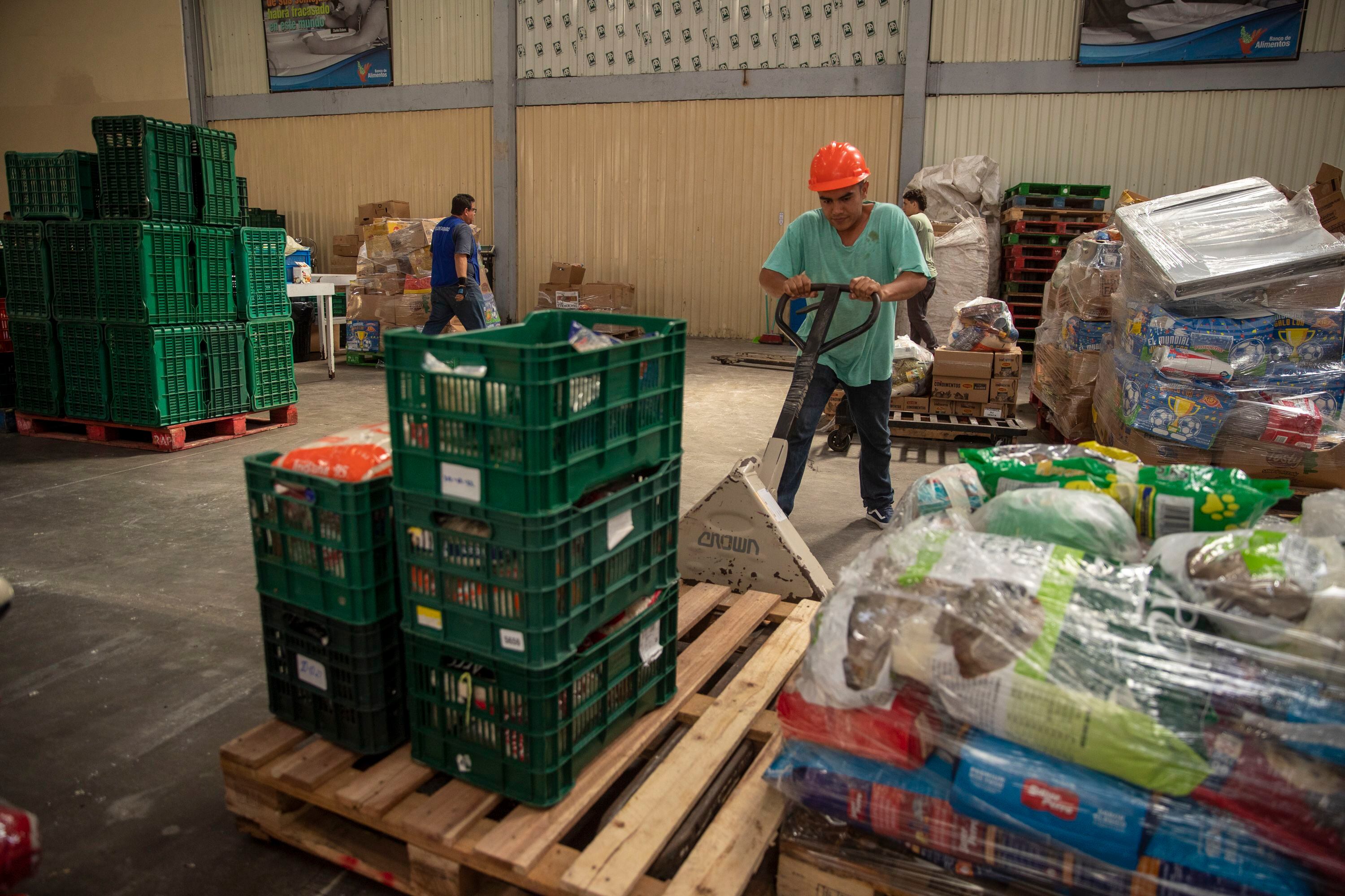  Densy Ruiz , colaborador del Banco de Alimentos, mueve varias cajas de productos que pronto serían despachadas a alguna organización de asistencia. 