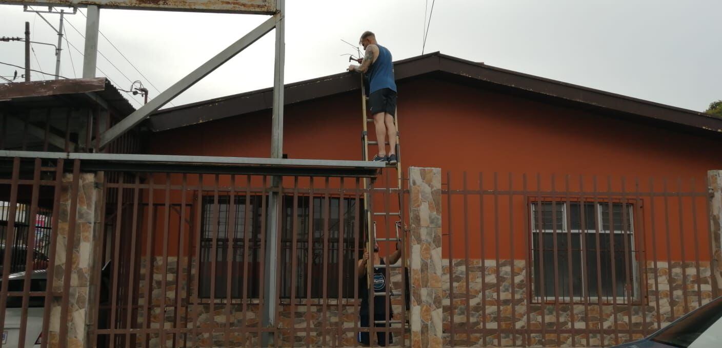 Dos hombres intentan reforzar el techo de esta casa ubicada en Dulce Nombre de Cartago. Algunos vecinos aseguran haber escuchado un retumbro similar al de un terremoto. Foto: Keyna Calderón.