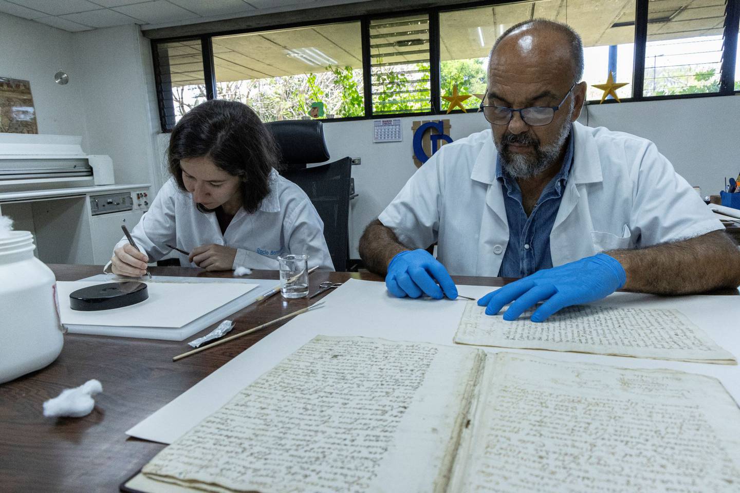 Los restauradores Rocío Bermúdez, de la UCR y Carlos Pacheco trabajan sobre los folios.

Fotografía: Archivo Nacional