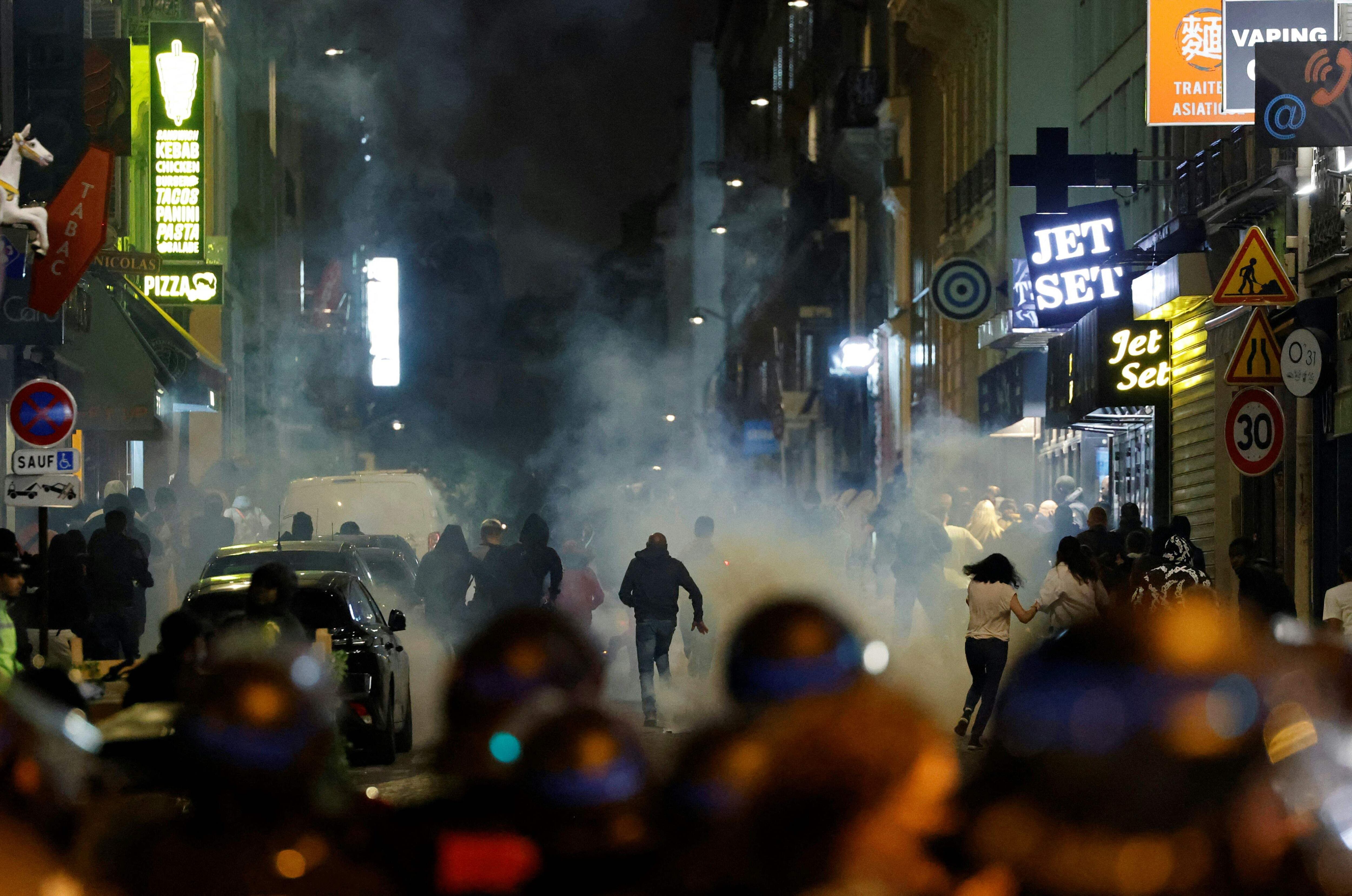 Los manifestantes corren mientras los policías franceses usan gases lacrimógenos en París, cinco días después de que la policía matara a un joven de 17 años en Nanterre, un suburbio al oeste de París.
La policía francesa arrestó a 1311 personas en todo el país durante la cuarta noche consecutiva de disturbios por el asesinato de un adolescente a manos de la policía.