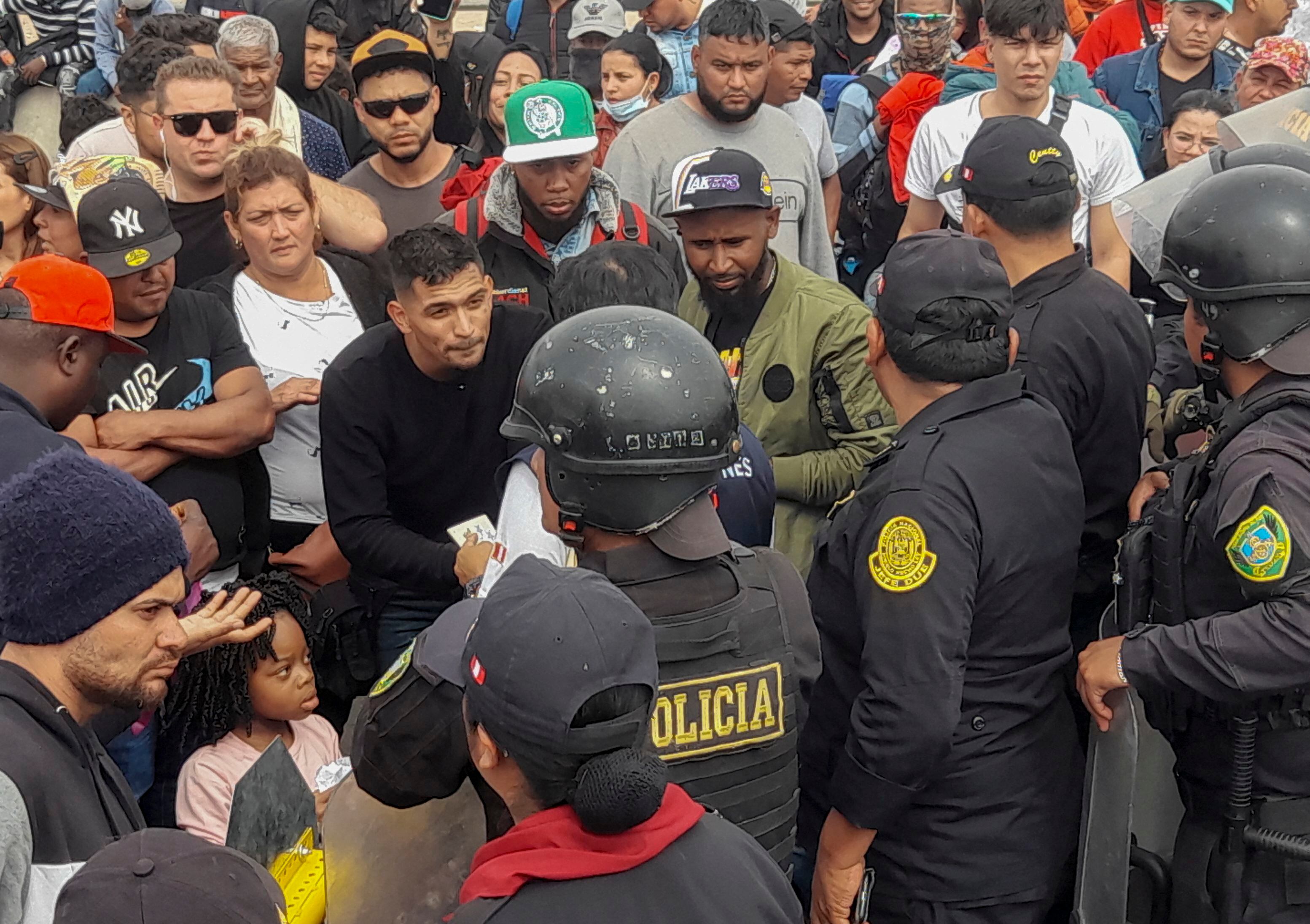 Policías peruanos impiden el ingreso a Perú, cerca de la sureña ciudad peruana de Tacna, a migrantes de diversas nacionalidades que permanecen varados en tierra de nadie en la frontera entre Perú y Chile.