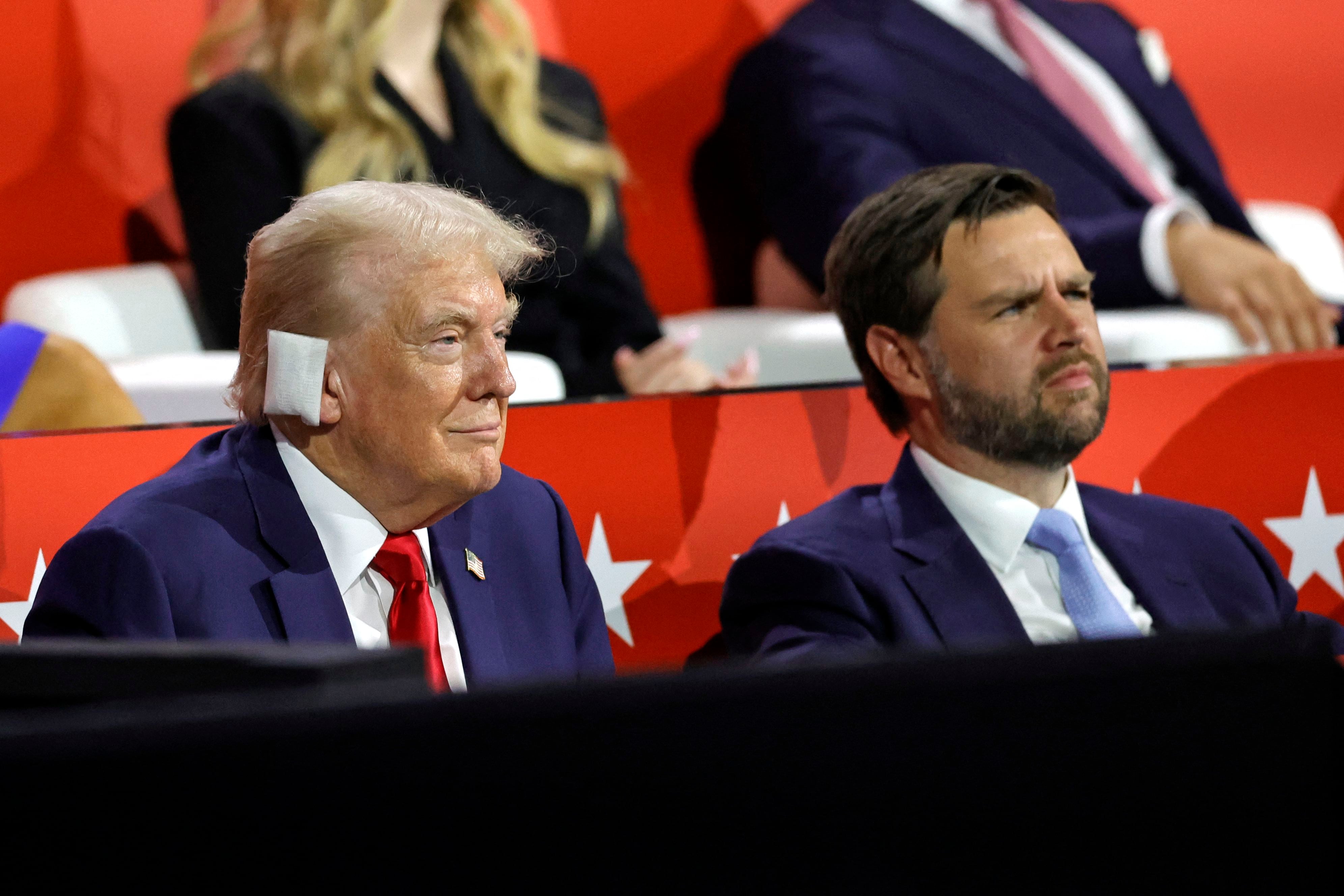 El expresidente estadounidense y candidato presidencial republicano, Donald Trump (izq.), se sienta junto al senador estadounidense de Ohio y al candidato republicano a vicepresidente, J. D. Vance, durante el primer día de la Convención Nacional Republicana de 2024.