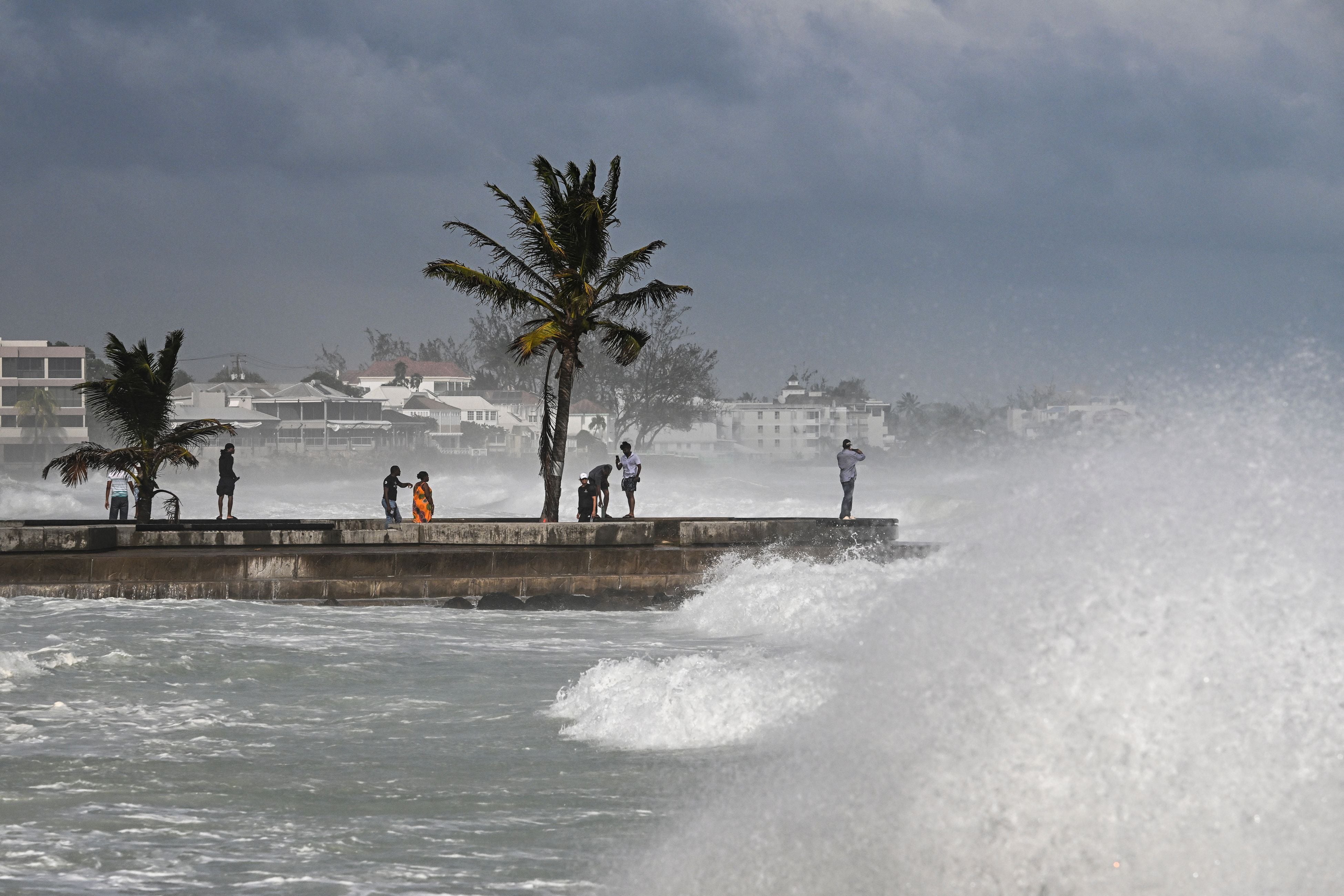 Personas visitan un muelle durante la marea alta después del paso del huracán Beryl en Oistins, cerca de Bridgetown, Barbados, el 1 de julio de 2024. El huracán Beryl causó devastadores vientos y fuertes lluvias en varias islas del Caribe el 1 de julio de 2024, marcando el evento más temprano registrado en la historia. La tormenta, clasificada como categoría 4, se movía hacia el oeste. (Foto de CHANDAN KHANNA / AFP)