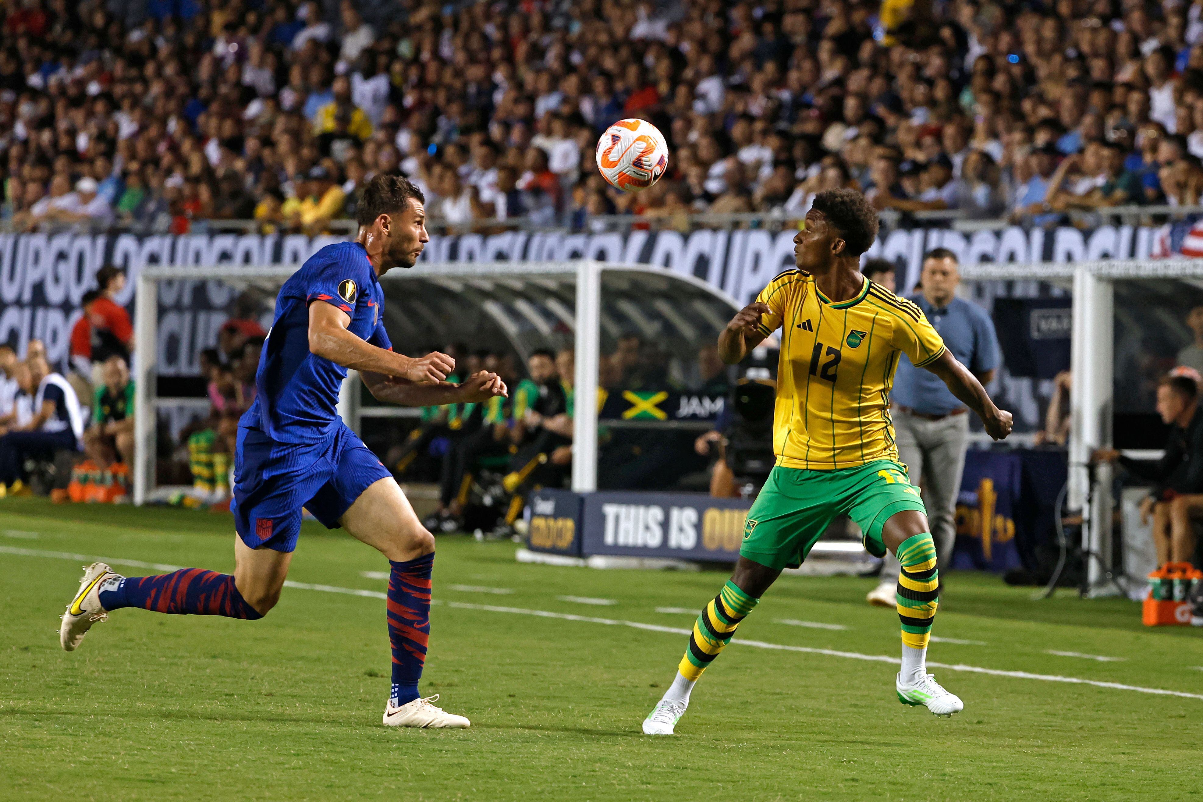 El defensor estadounidense Matt Miazga lucha por el balón en el delantero jamaiquino Demarai Gray en el primer partido del grupo A en la Copa Oro.