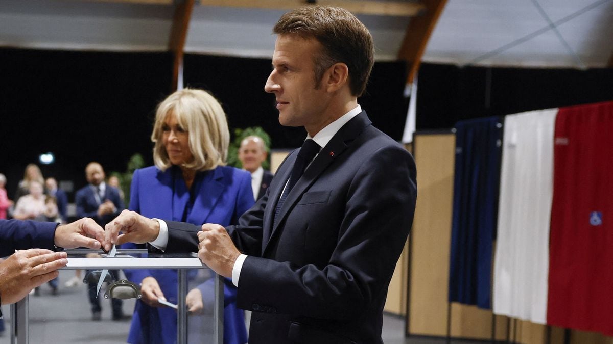El presidente francés, Emmanuel Macron, introduce su voto en la urna junto a su esposa. Foto: AFP