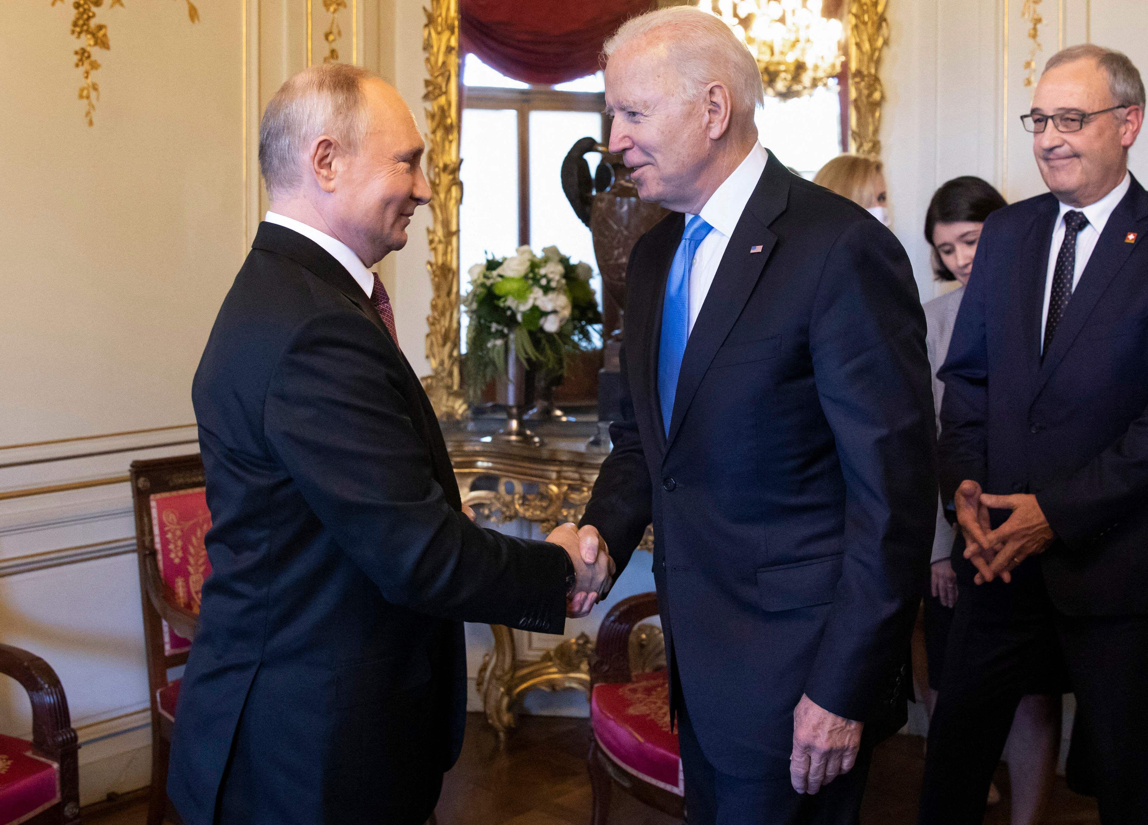 US President Joe Biden (C) shakes hands with Russian President Vladimir Putin (L) prior to the US-Russia summit at the Villa La Grange, in Geneva on June 16, 2021. (Photo by PETER KLAUNZER / POOL / AFP)
