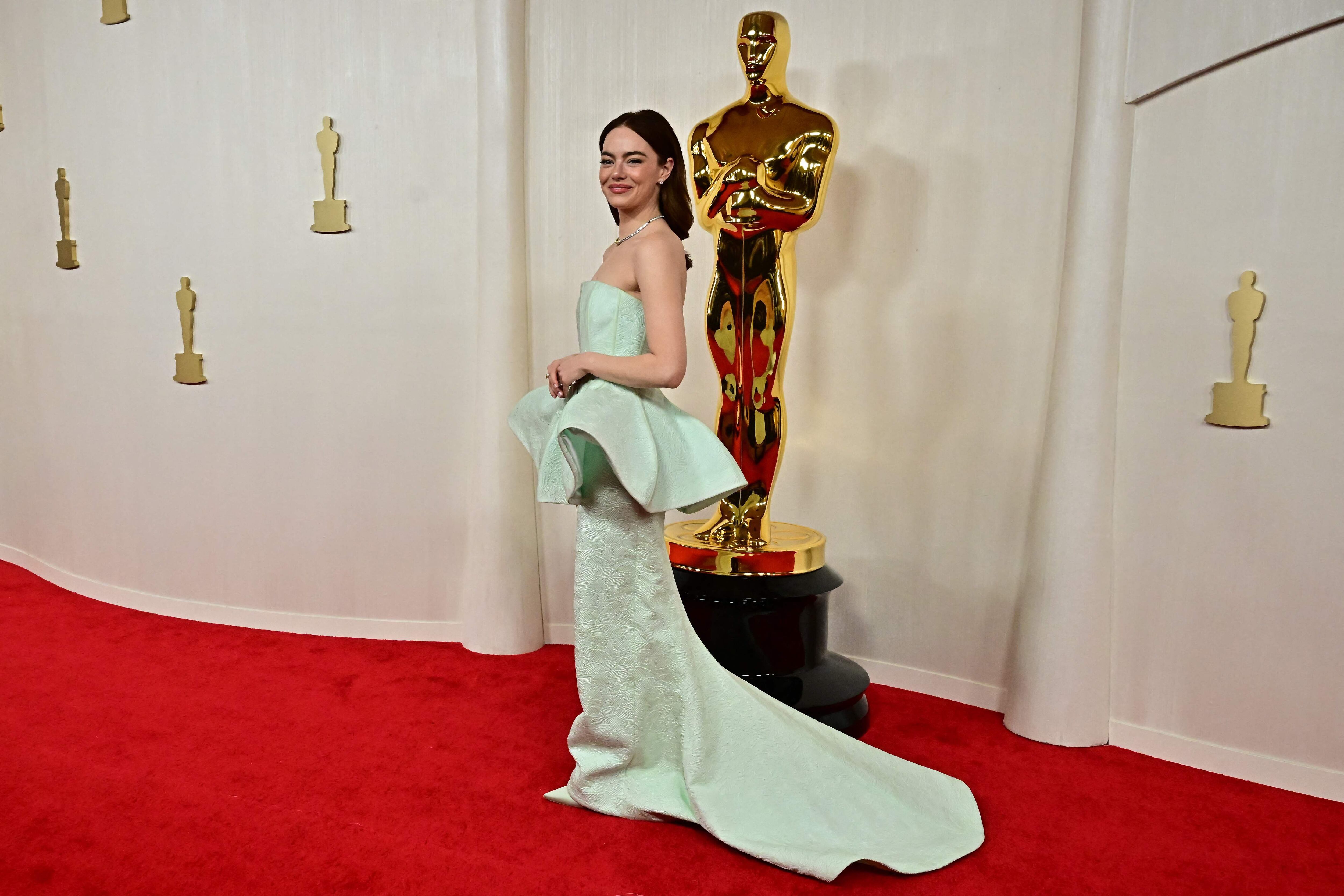 La actriz estadounidense Emma Stone eligió un sobrio vestido strapless en color verde menta para asistir a la gala número 96 de los Premios Óscar. La estrella complementó su vestuario con su cabello suelto y un collar. 