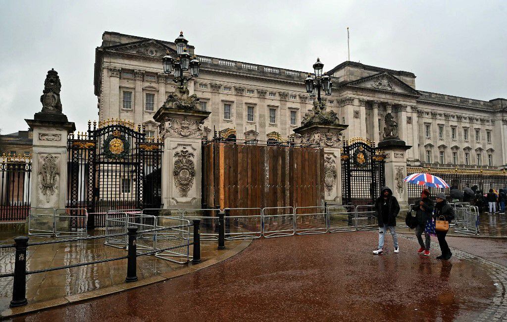 Peatones junto a portones del Palacio de Buckingham, en Londres, este 10 de marzo del 2024, en el punto por donde un automóvil chocó contra ese acceso al palacio real. 